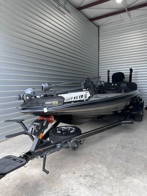 A 2023 Skeeter FXR21 Apex boat on a trailer in a storage facility.