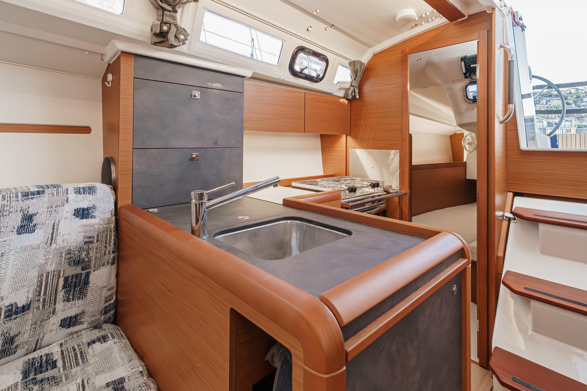 Interior of 2022 Jeanneau Sun Odyssey 349 sailboat, featuring modern kitchen and seating area.