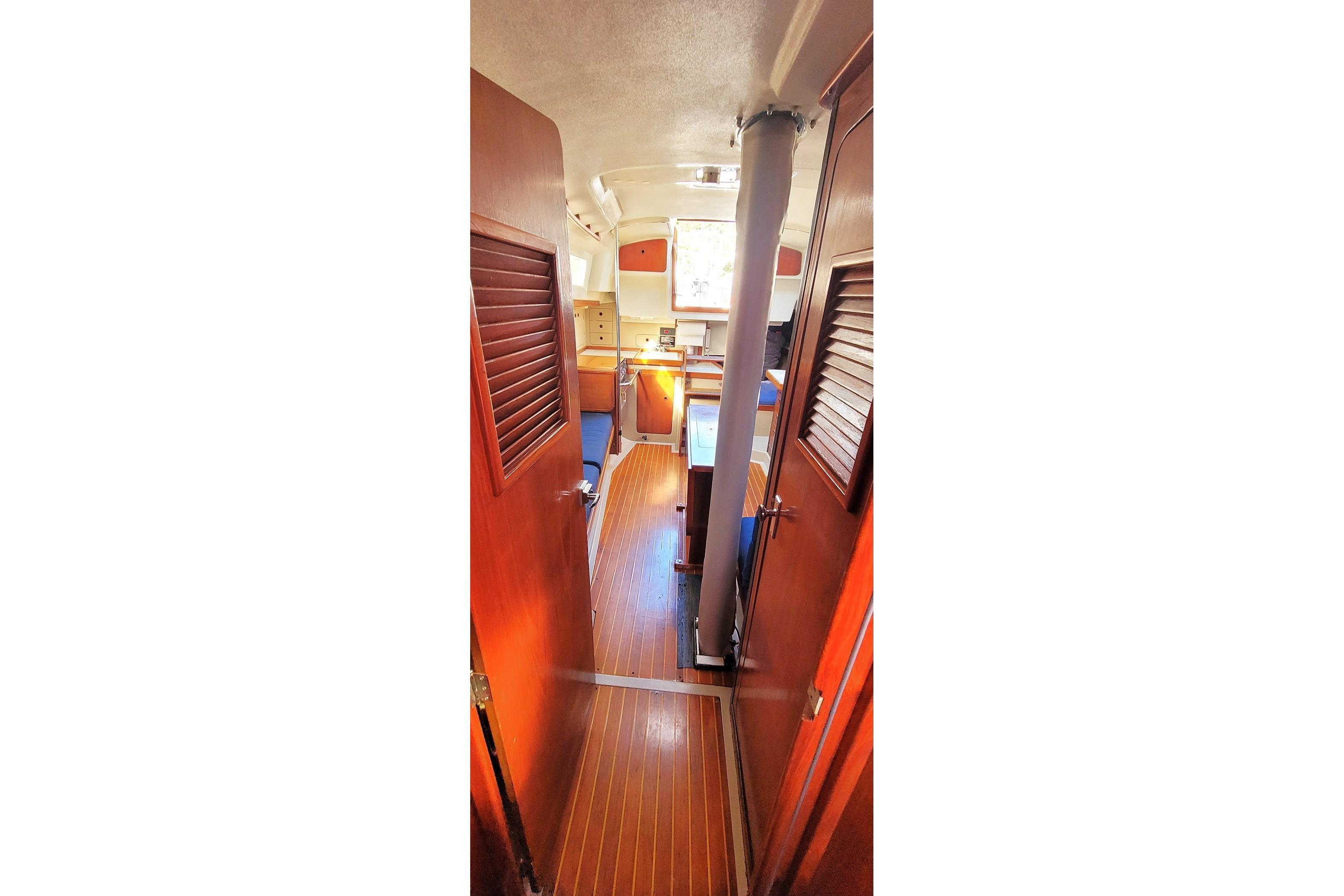 Interior view of 1985 C&C 33 MK II sailboat, featuring wooden flooring and cabinetry.