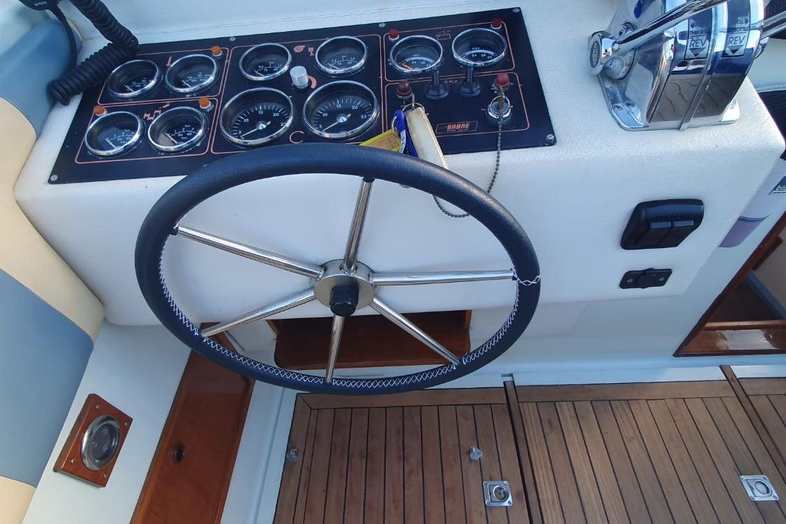 Steering wheel and dashboard of 1989 Fairey Spearfish MKIII boat with gauges and controls.