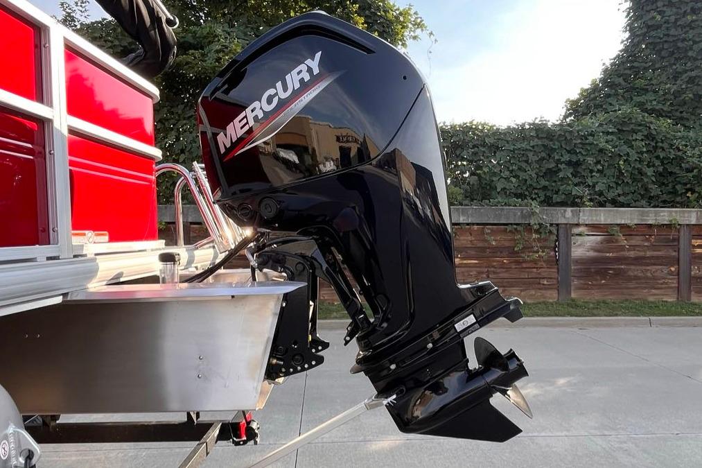2026 Sun Tracker Party Barge 18 DLX with Mercury outboard motor, parked outdoors.