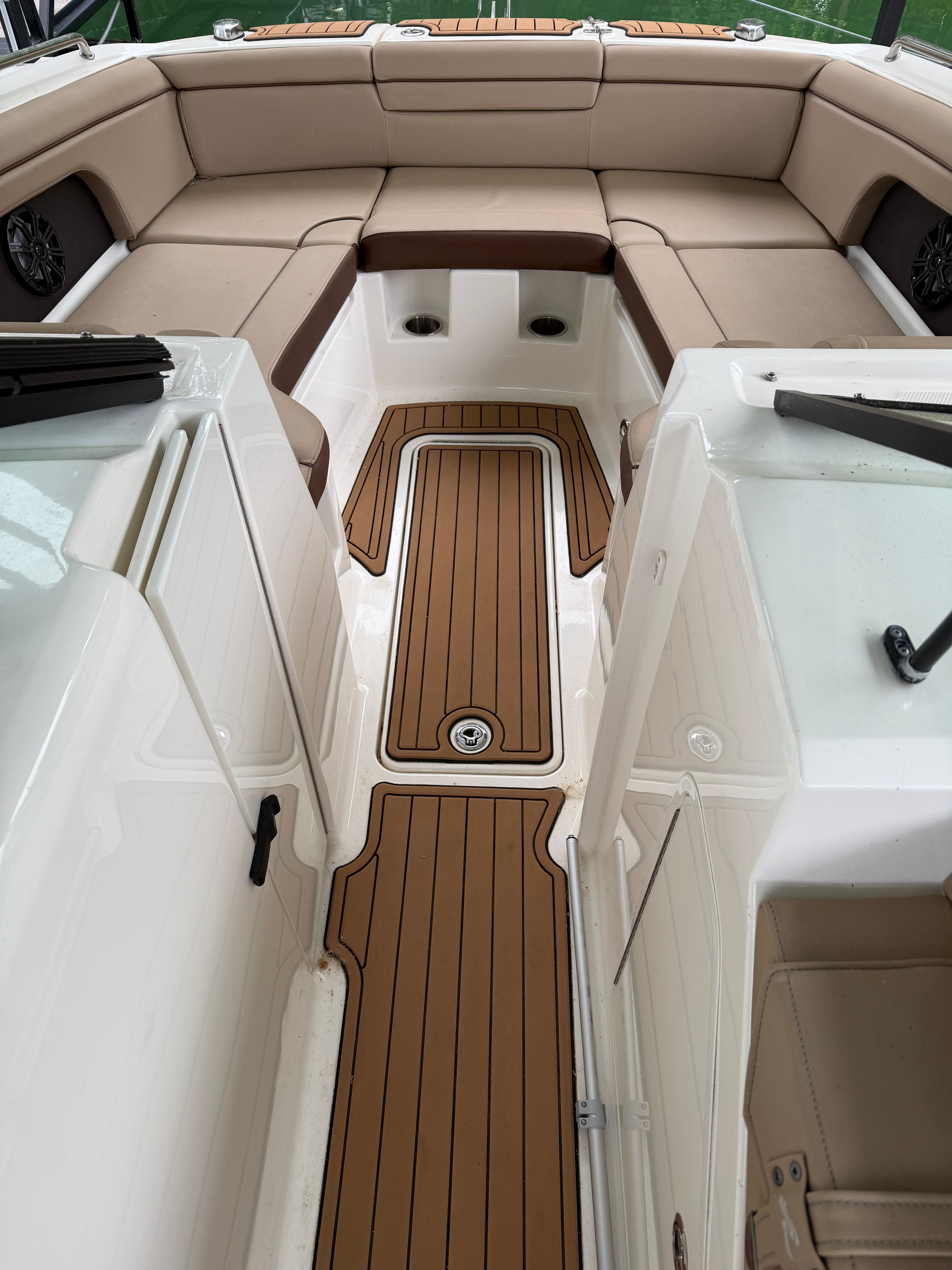 Interior of a 2016 Sea Ray 290 Sundeck with wood flooring and beige seating.