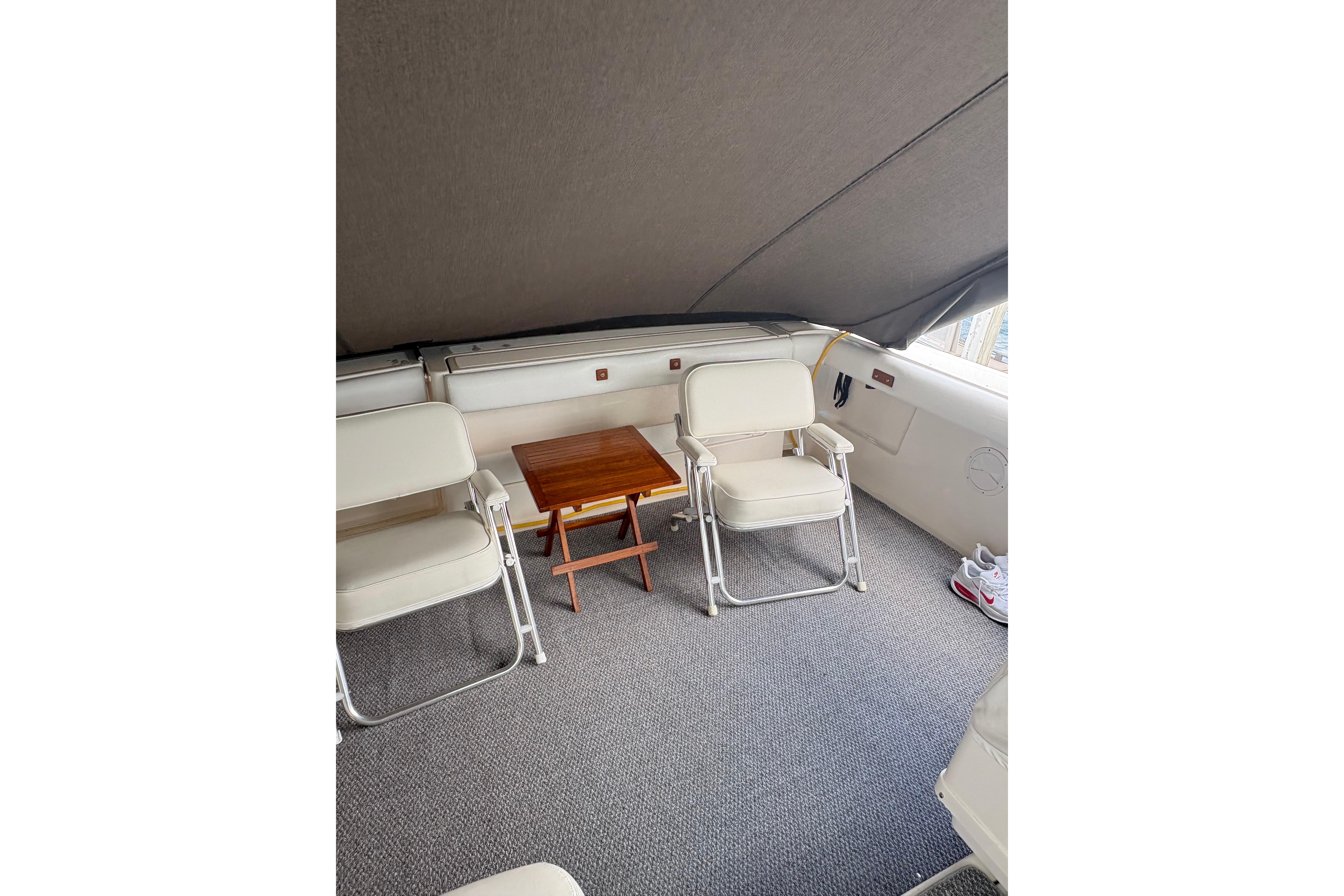 1999 Tiara Yachts 3100 Open interior with chairs and table under canopy.