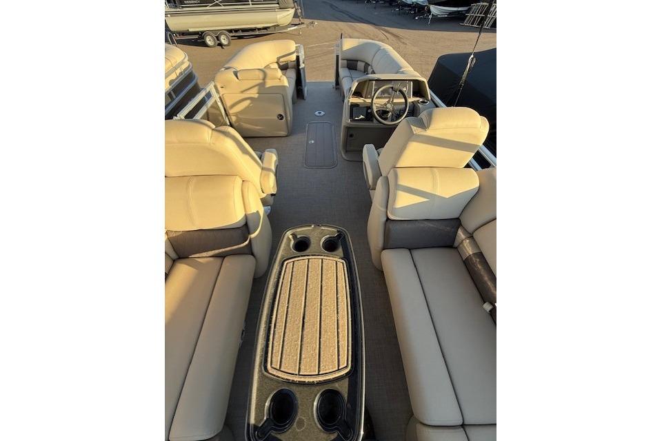 2025 Sun Tracker Party Barge 22 XP3 interior with beige seating and steering console.