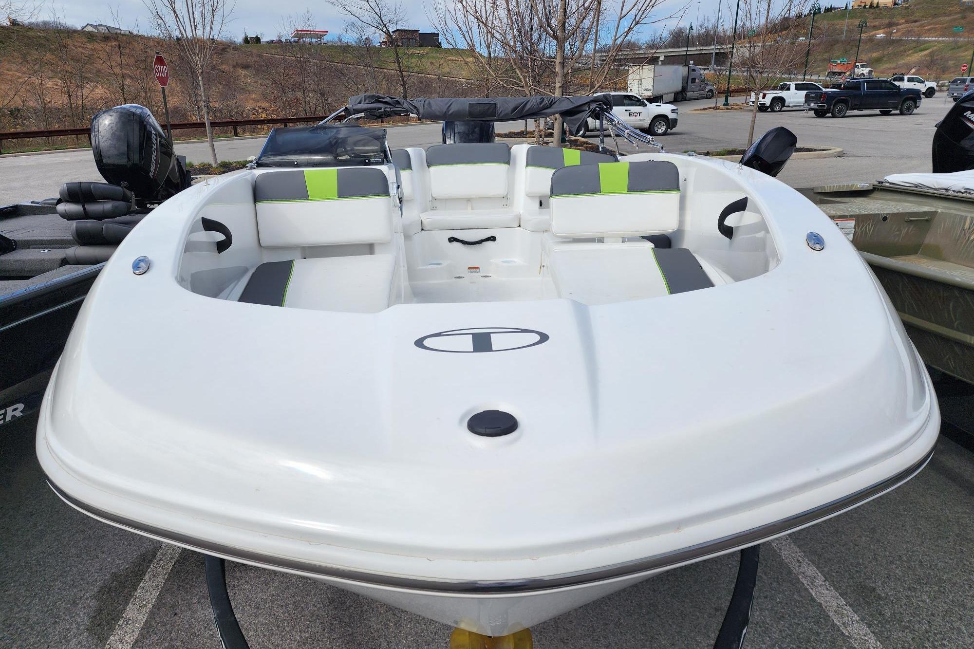 2023 Tahoe T18 boat with sleek white design and green accents, parked outdoors.