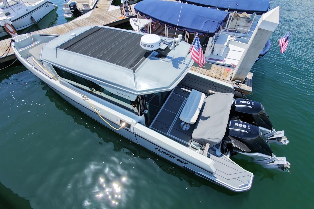 2024 Saxdor 320 GTC boat docked, featuring sleek design and dual outboard motors.