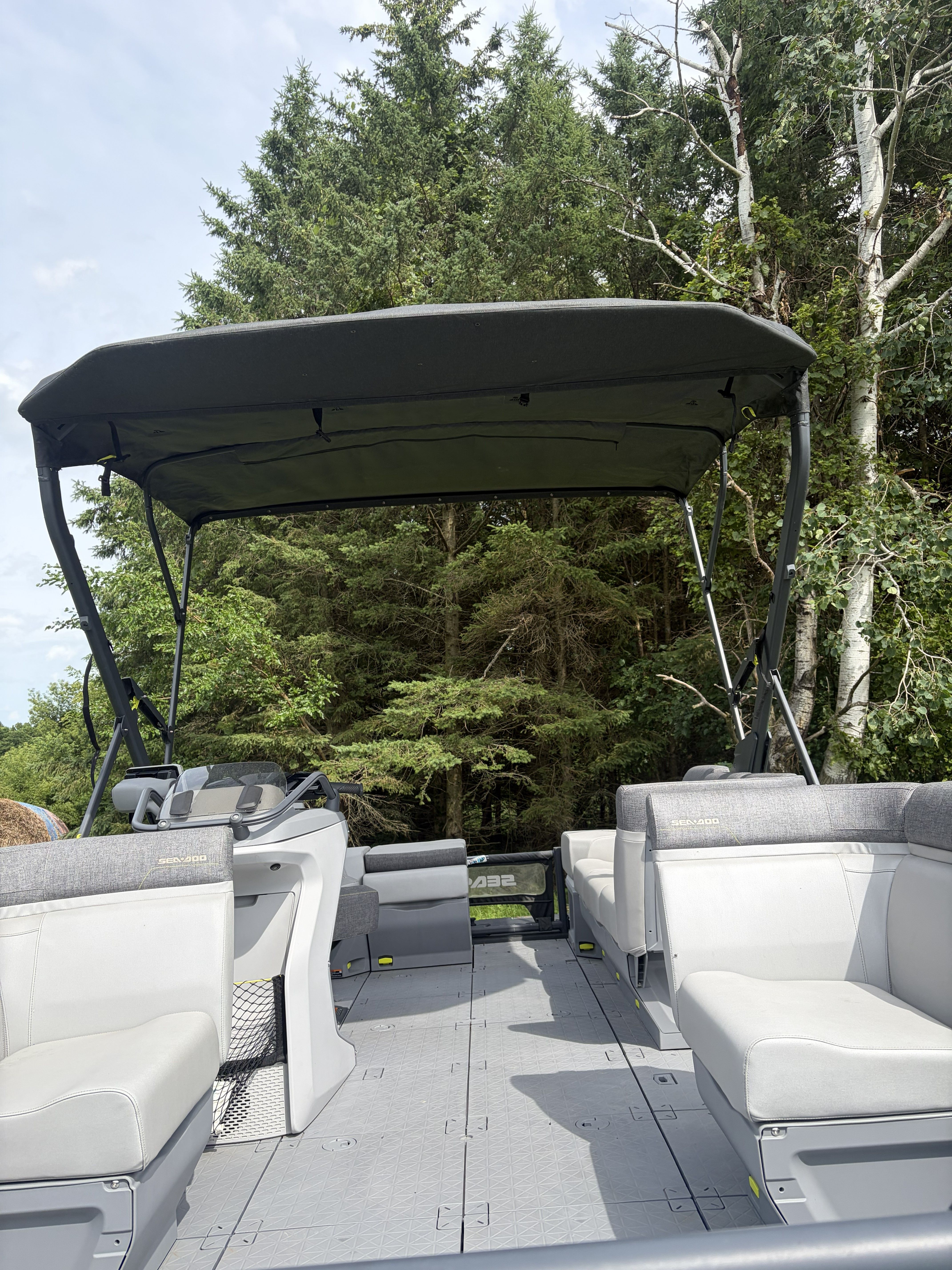 The image shows a 2023 Custom Sea Doo Switch pontoon boat with gray seats and a black canopy.