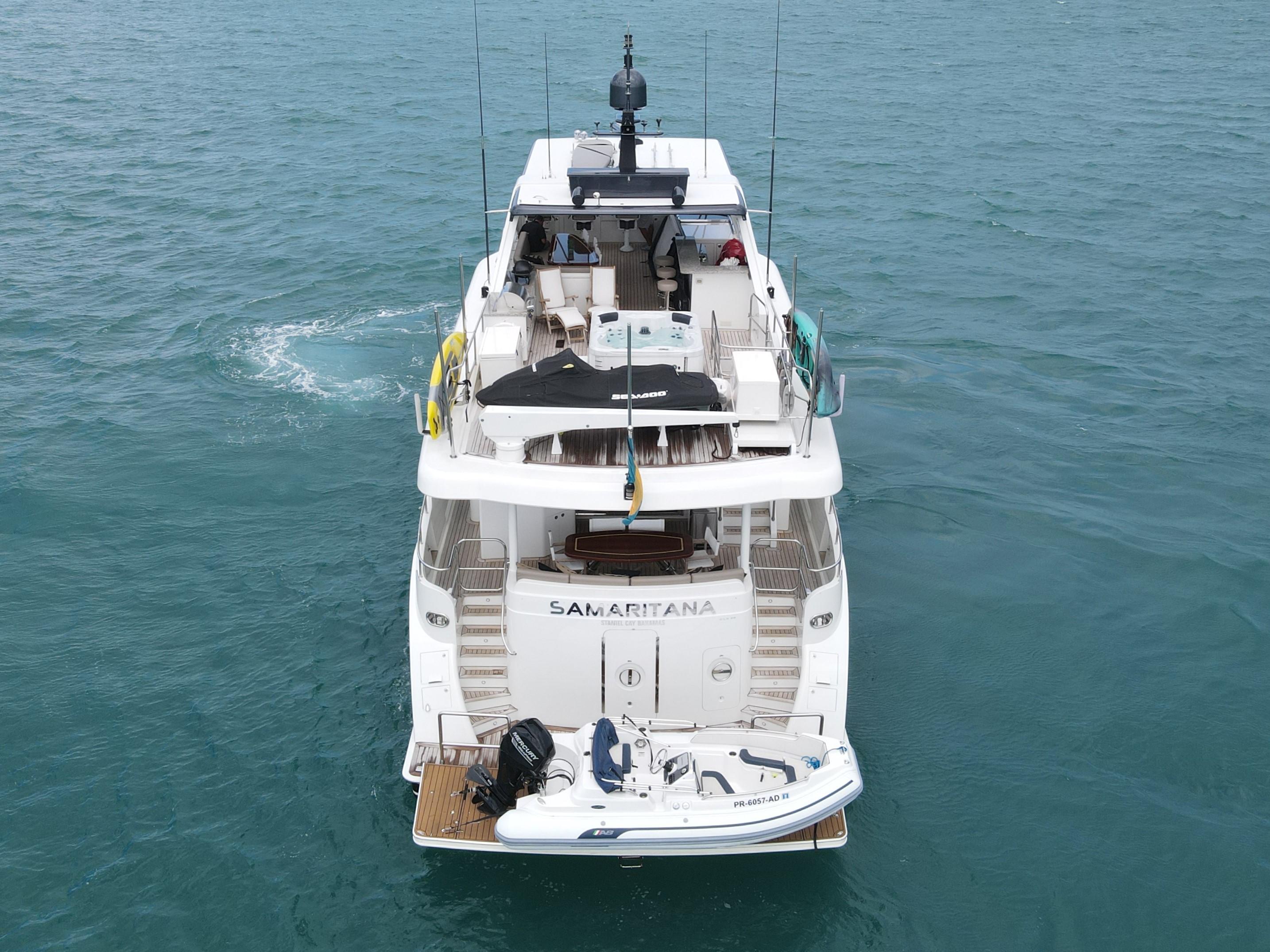 2013 Cheoy Lee Bravo yacht on water, rear view with small boat attached.