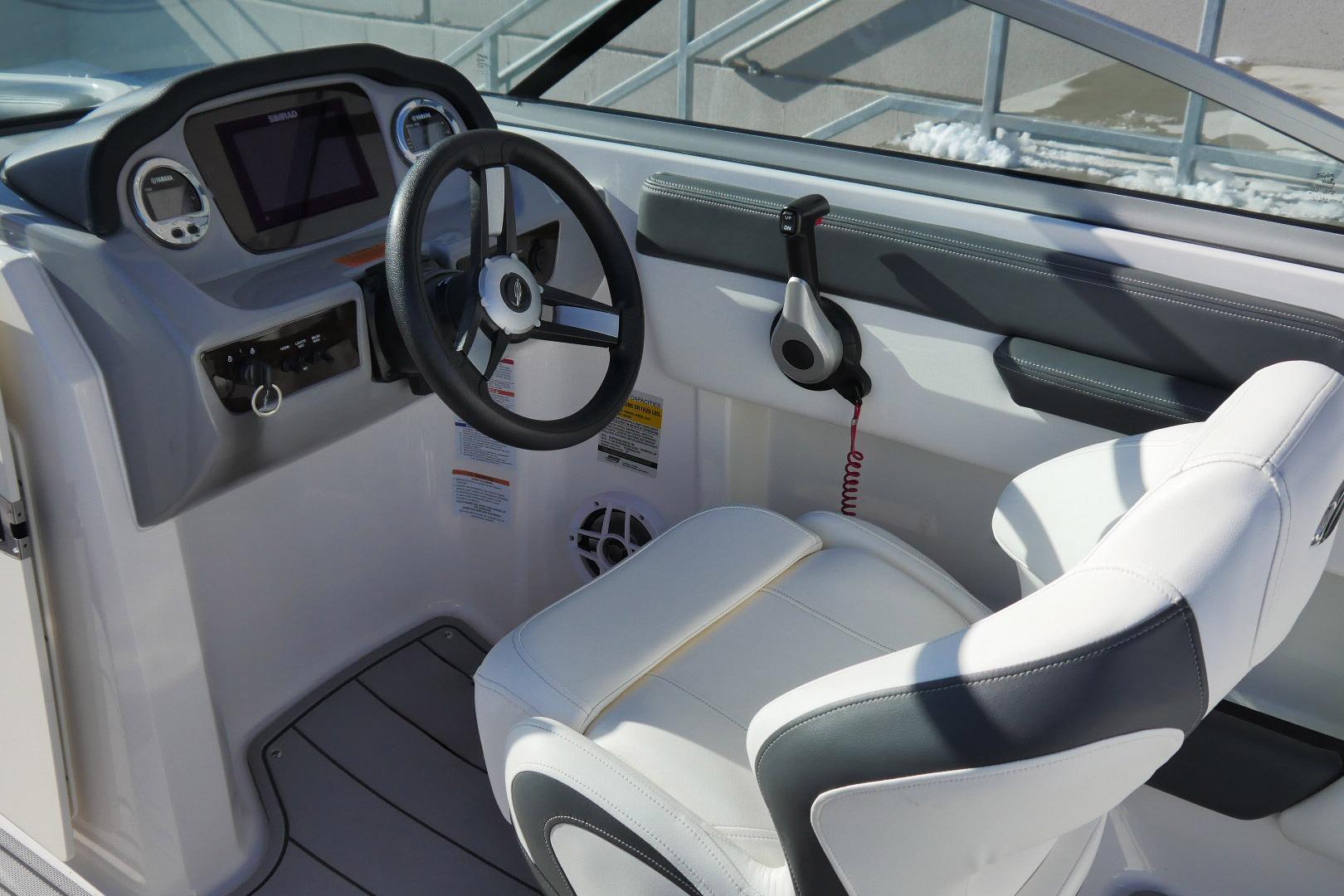 2023 Chaparral 21 SSi Ski & Fish OB boat cockpit with steering wheel and controls.