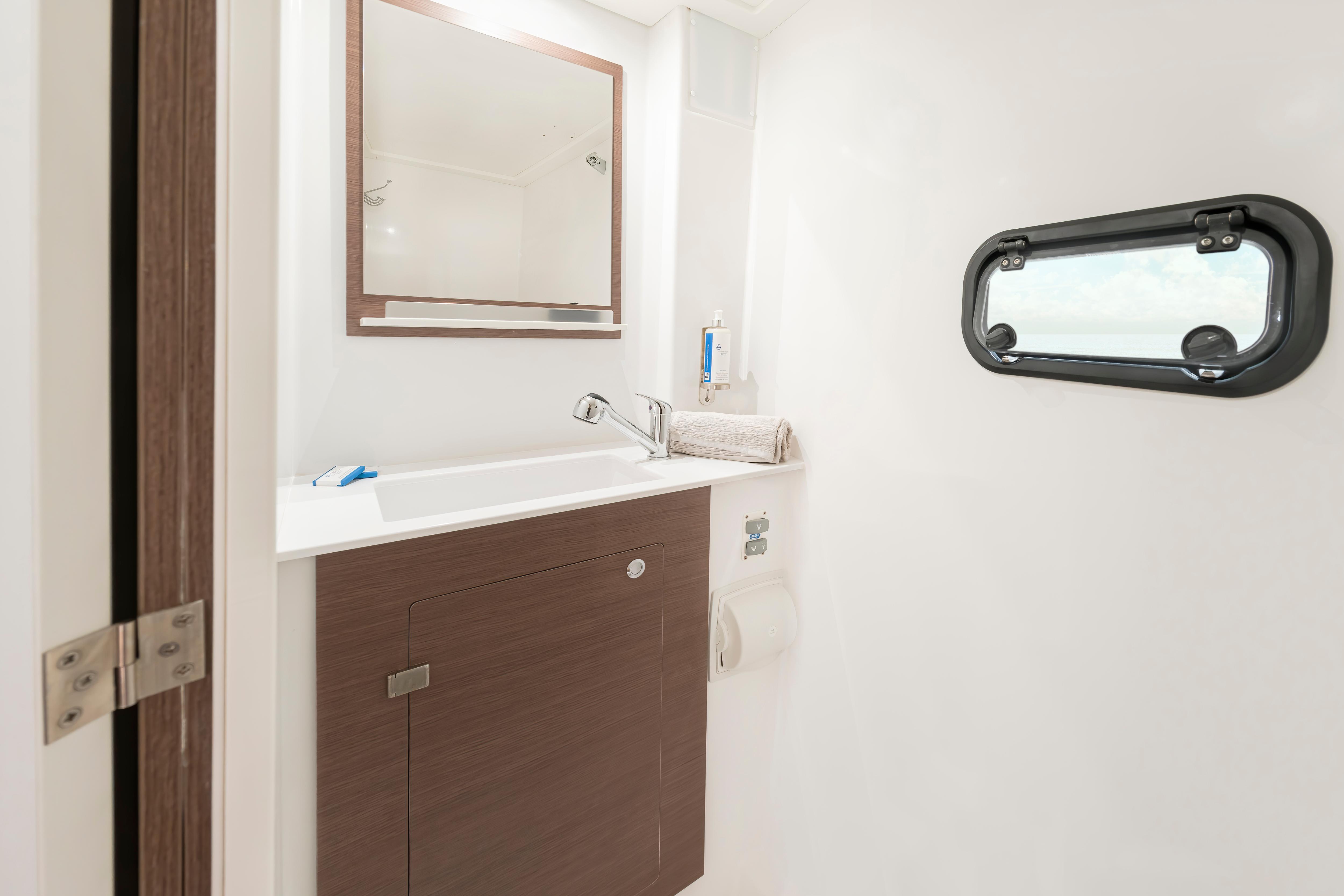 Modern bathroom interior of 2025 Bali CATSPACE SAIL yacht with sleek design and porthole window.