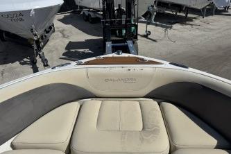 2019 Bryant Calandra 23 boat interior with beige seating, docked near other boats.