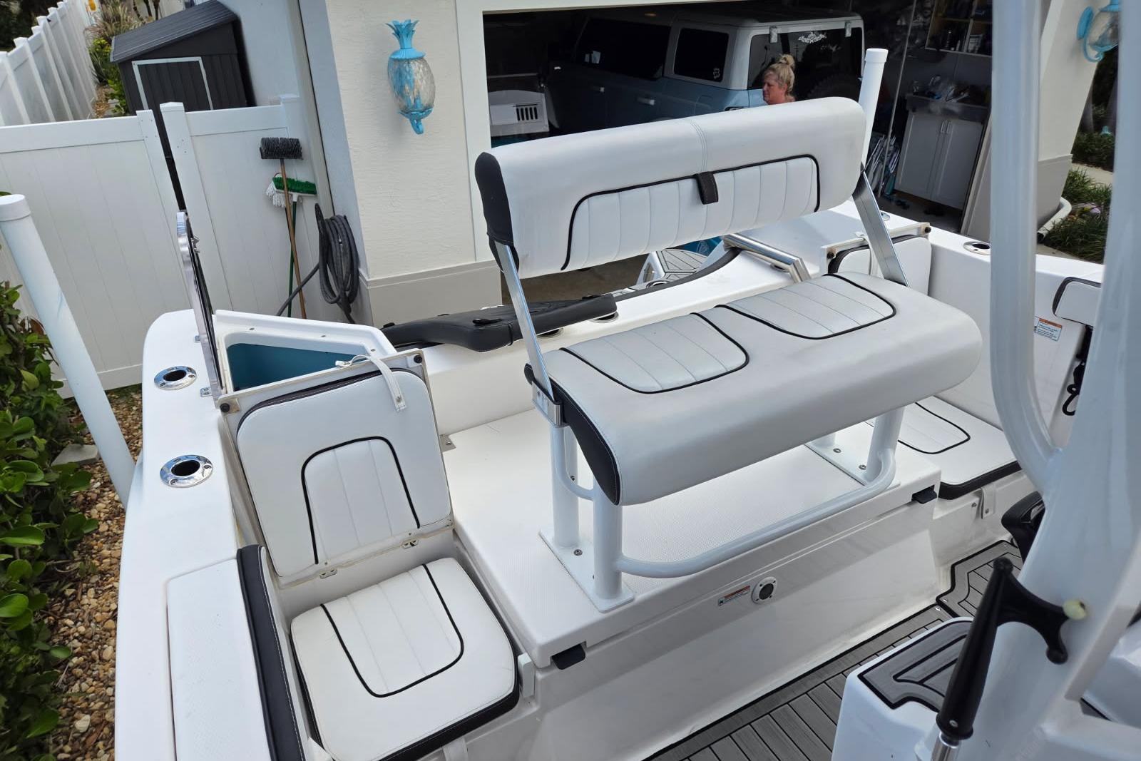 2024 Yamaha Boats 222 FSH Sport E interior with white seating and storage compartments.