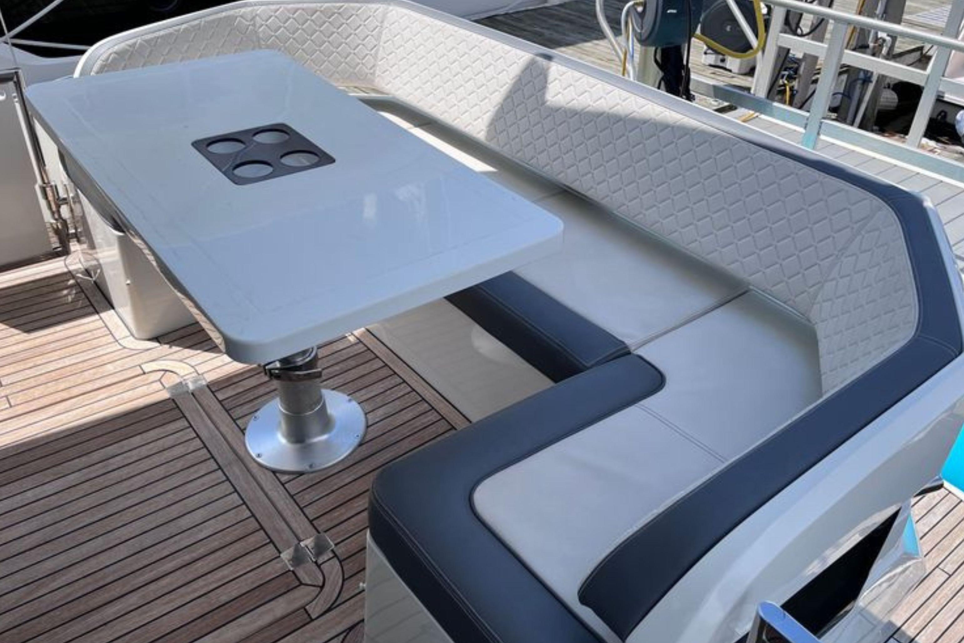 Luxurious seating area on 2024 Galeon 425 HTS yacht with elegant table and cushioned benches.