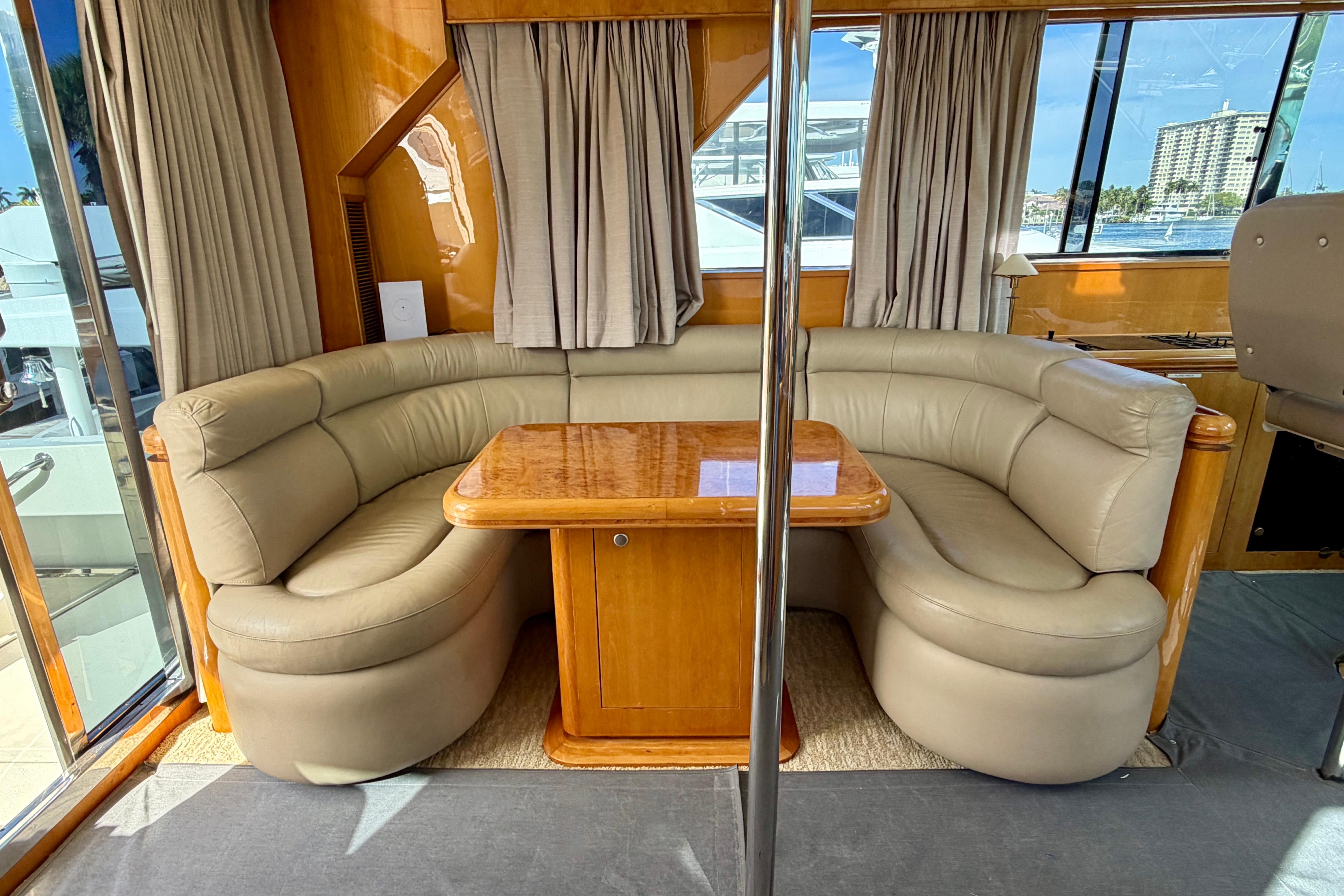 Luxurious Horizon 92 yacht interior with curved leather seating and wooden table.