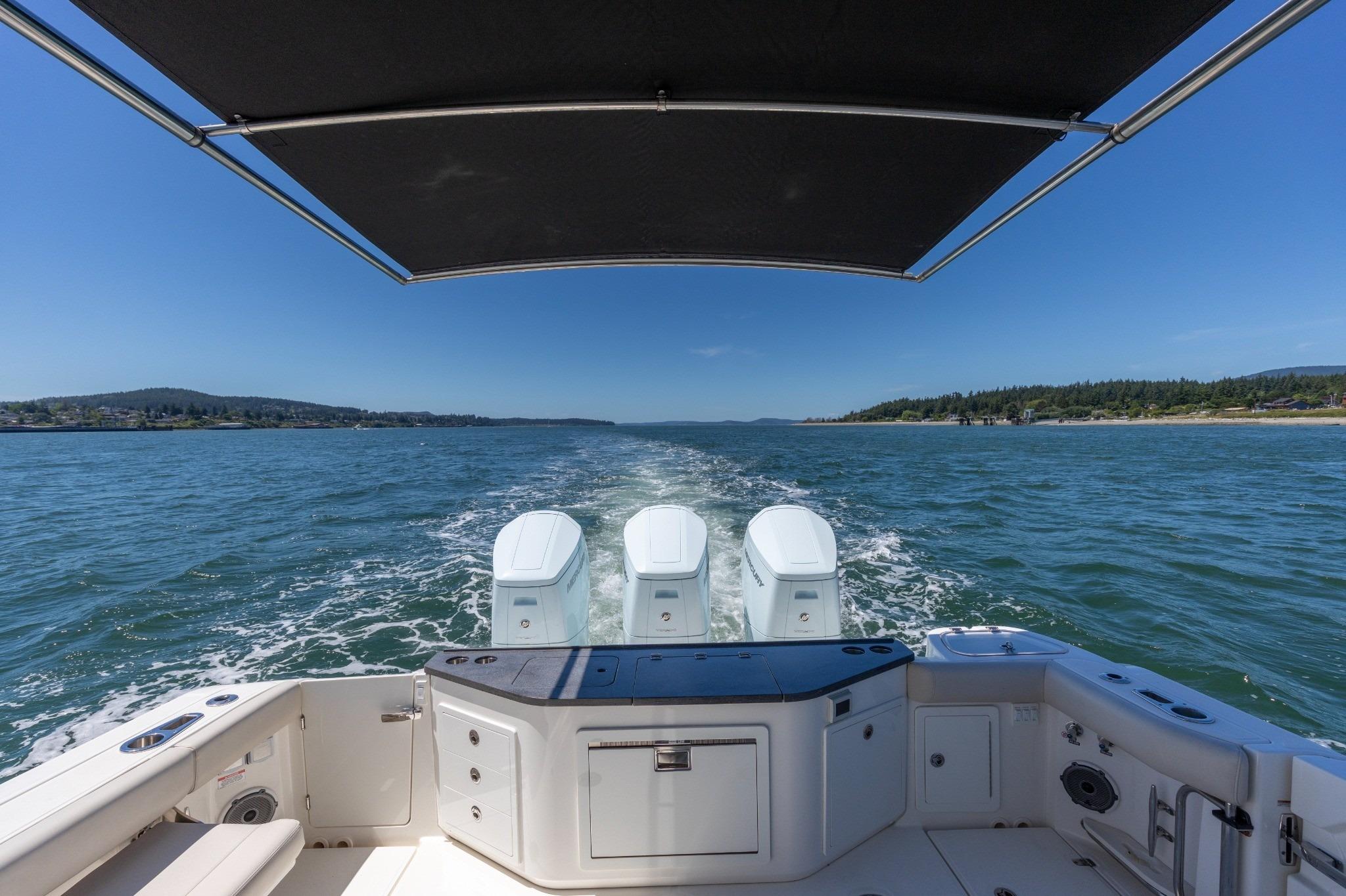 Boston Whaler 405 Conquest 2023 cruising on open water under a clear blue sky.