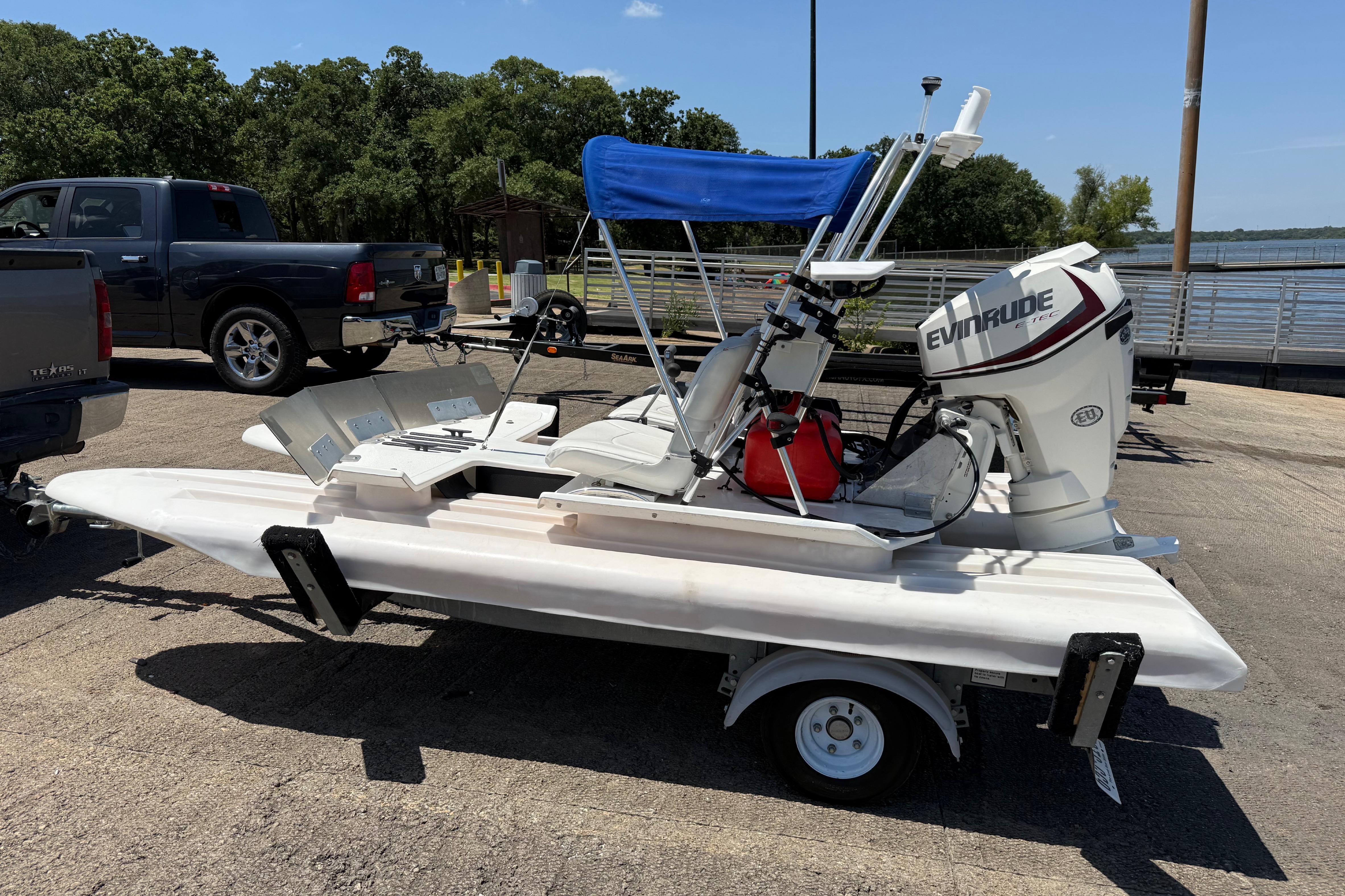 2016 CraigCat E2 Elite boat on trailer with Evinrude motor, parked near a lake.