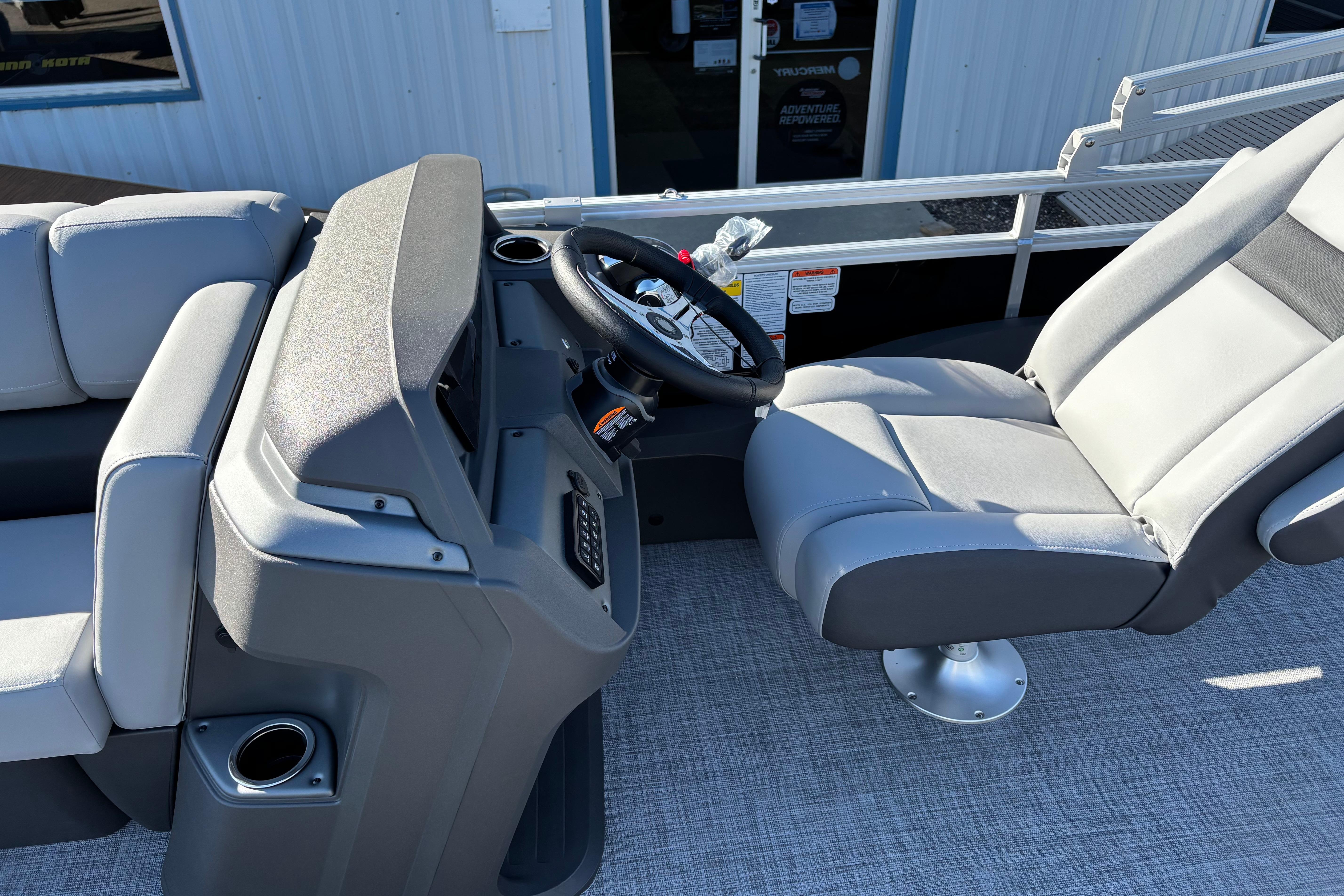 2026 Sun Tracker SportFish 22 XP3 boat interior with steering console and seating.