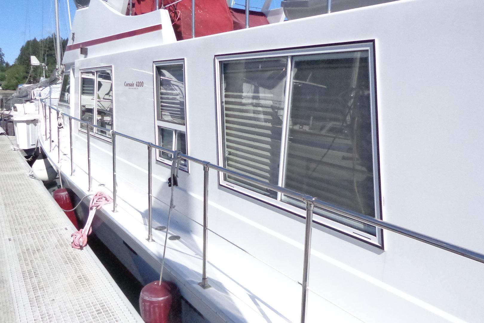 1992 Cruise-A-Home Corsair 4200 docked, showcasing sleek white exterior and large windows.