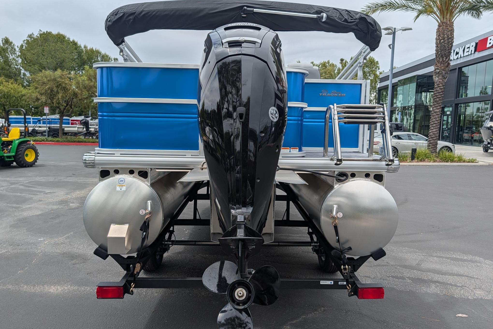 2026 Sun Tracker Party Barge 18 DLX pontoon boat with outboard motor, rear view.