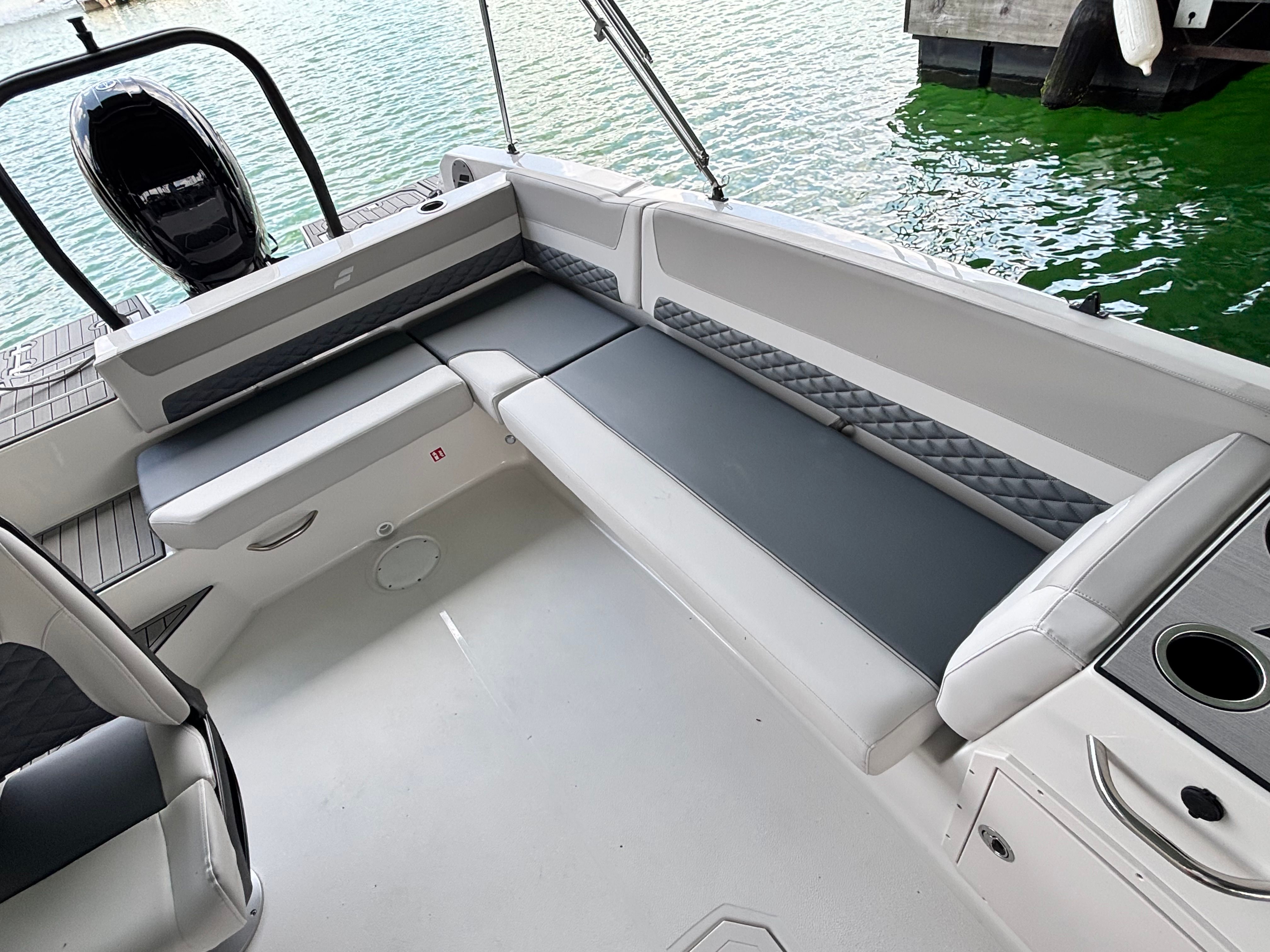 The image shows the interior of a 2027 Starcraft 211SVXOB boat with gray seating cushions.