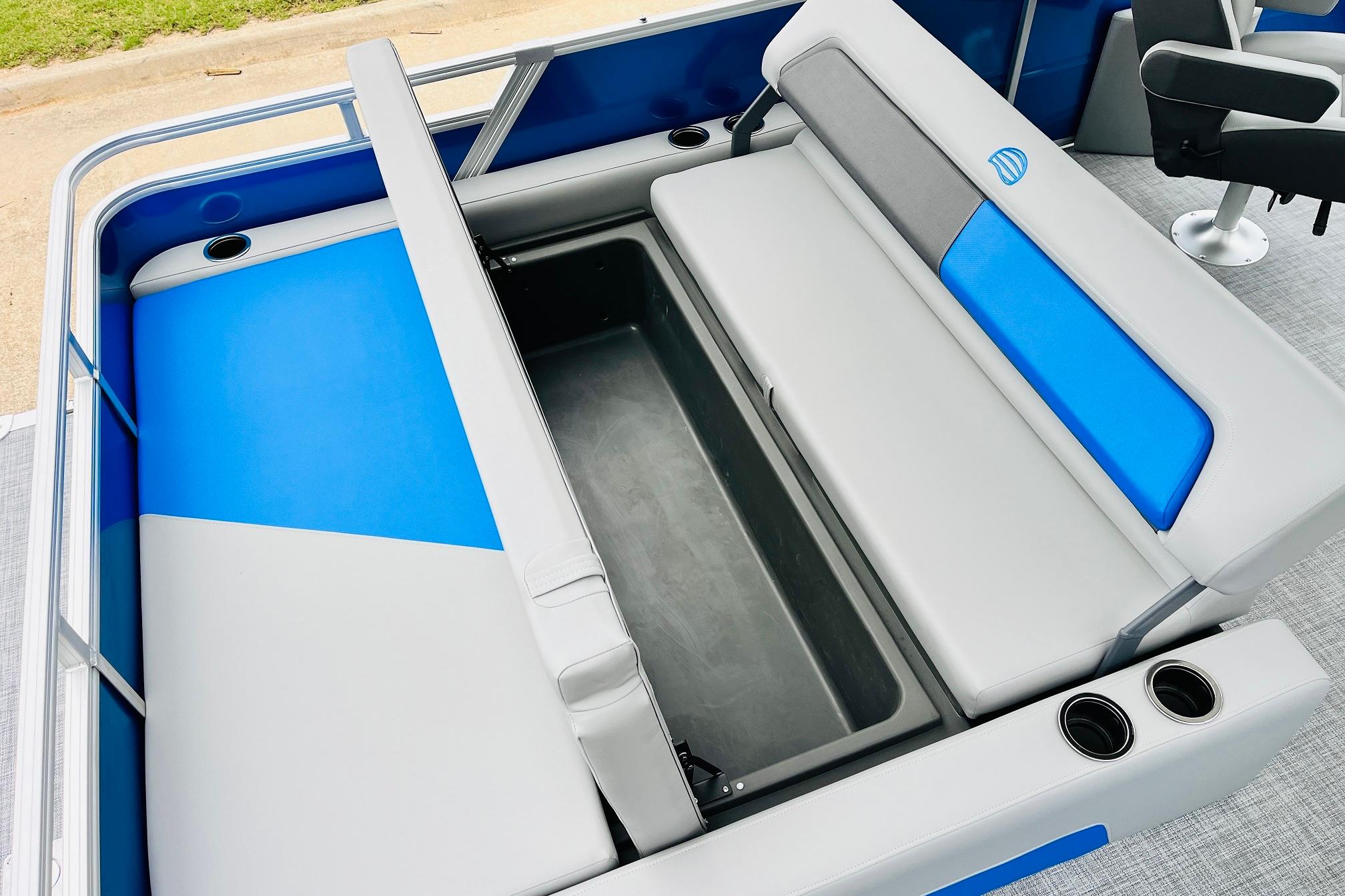 2026 Sun Tracker Party Barge 22 RF DLX seating with storage compartment and cup holders.
