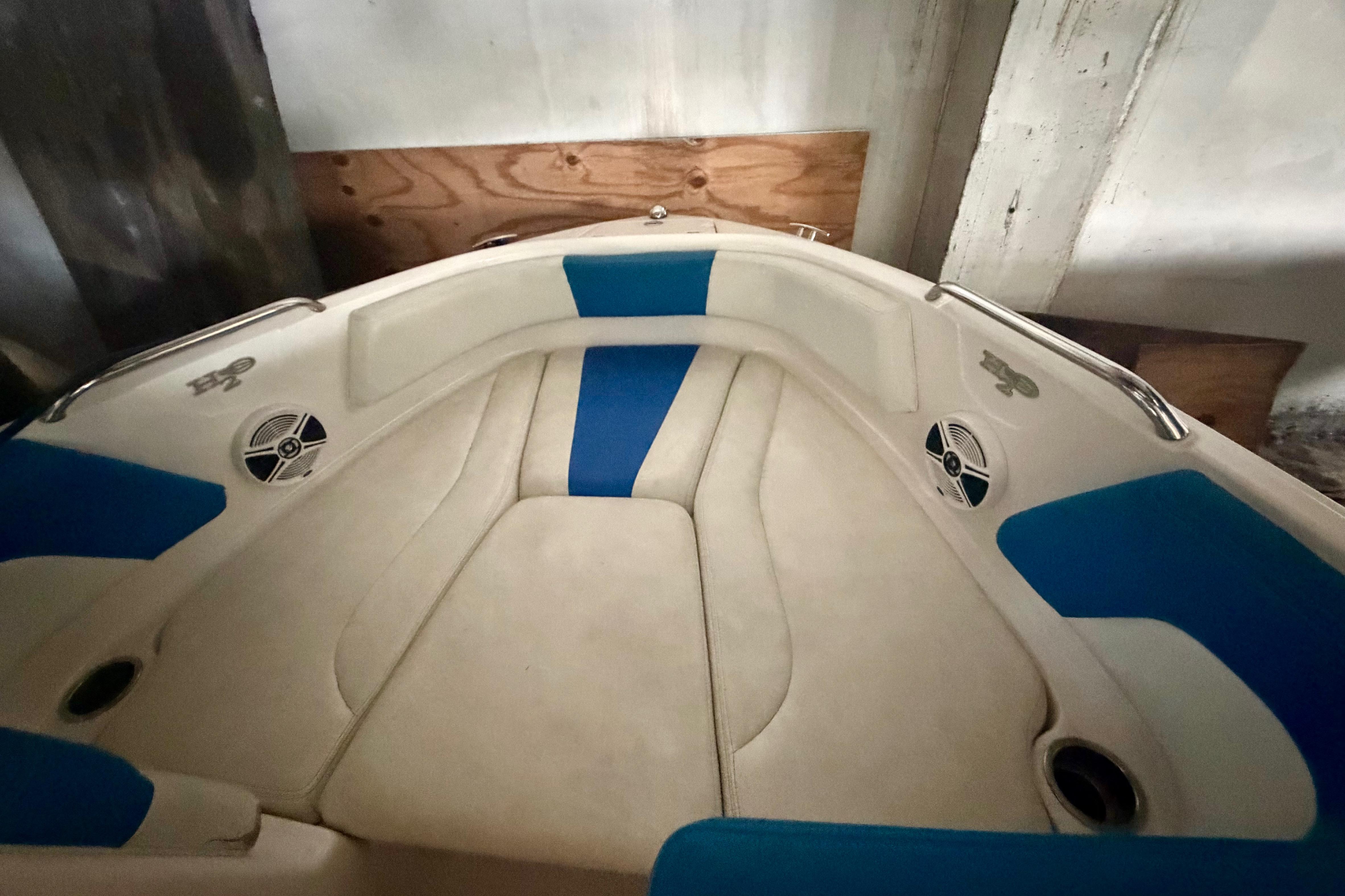 Interior view of 2018 Chaparral 21 H2O Sport boat with blue and beige seating.