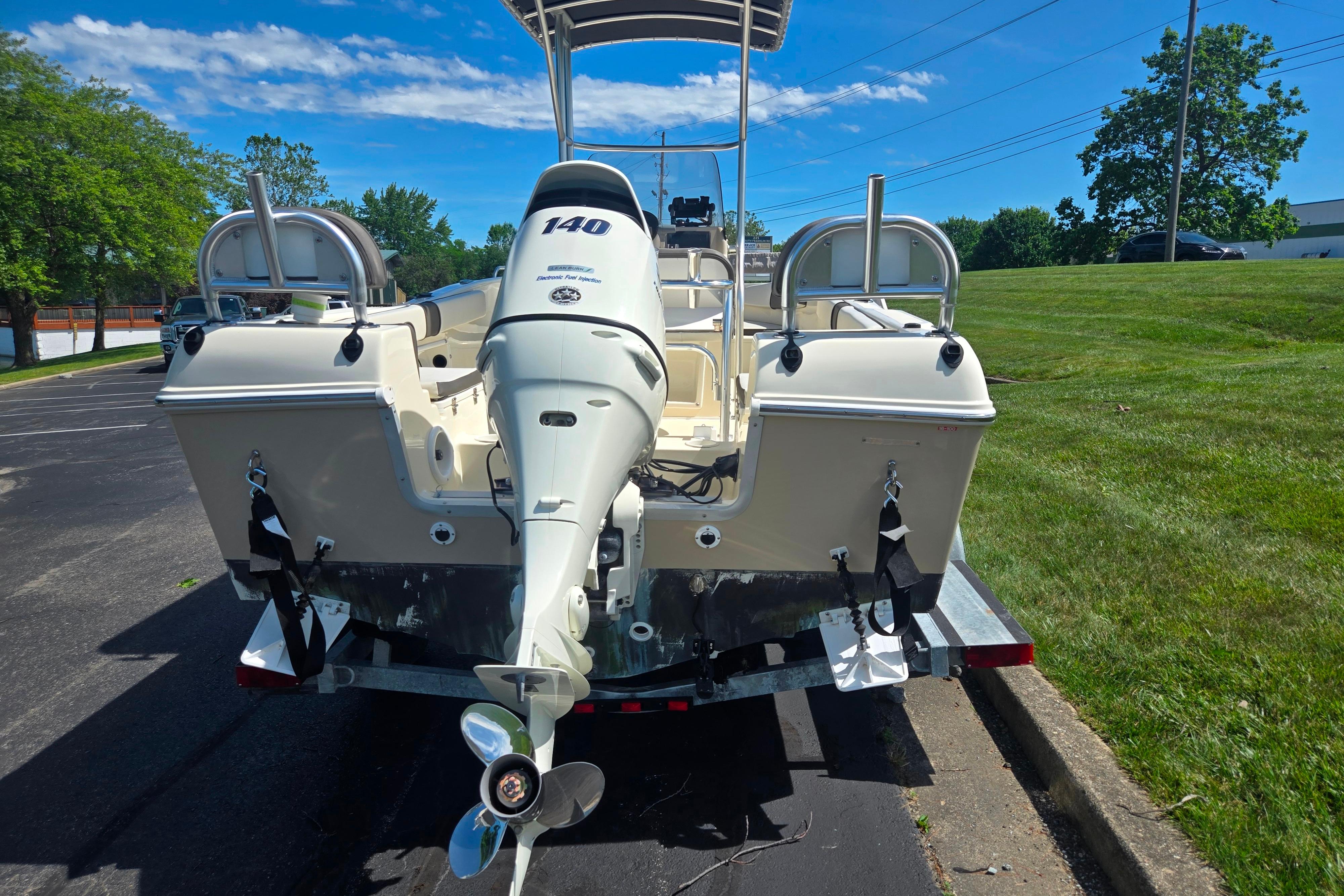 Key Largo 2000CC 2016 boat with 140 HP engine on a trailer, parked outdoors.