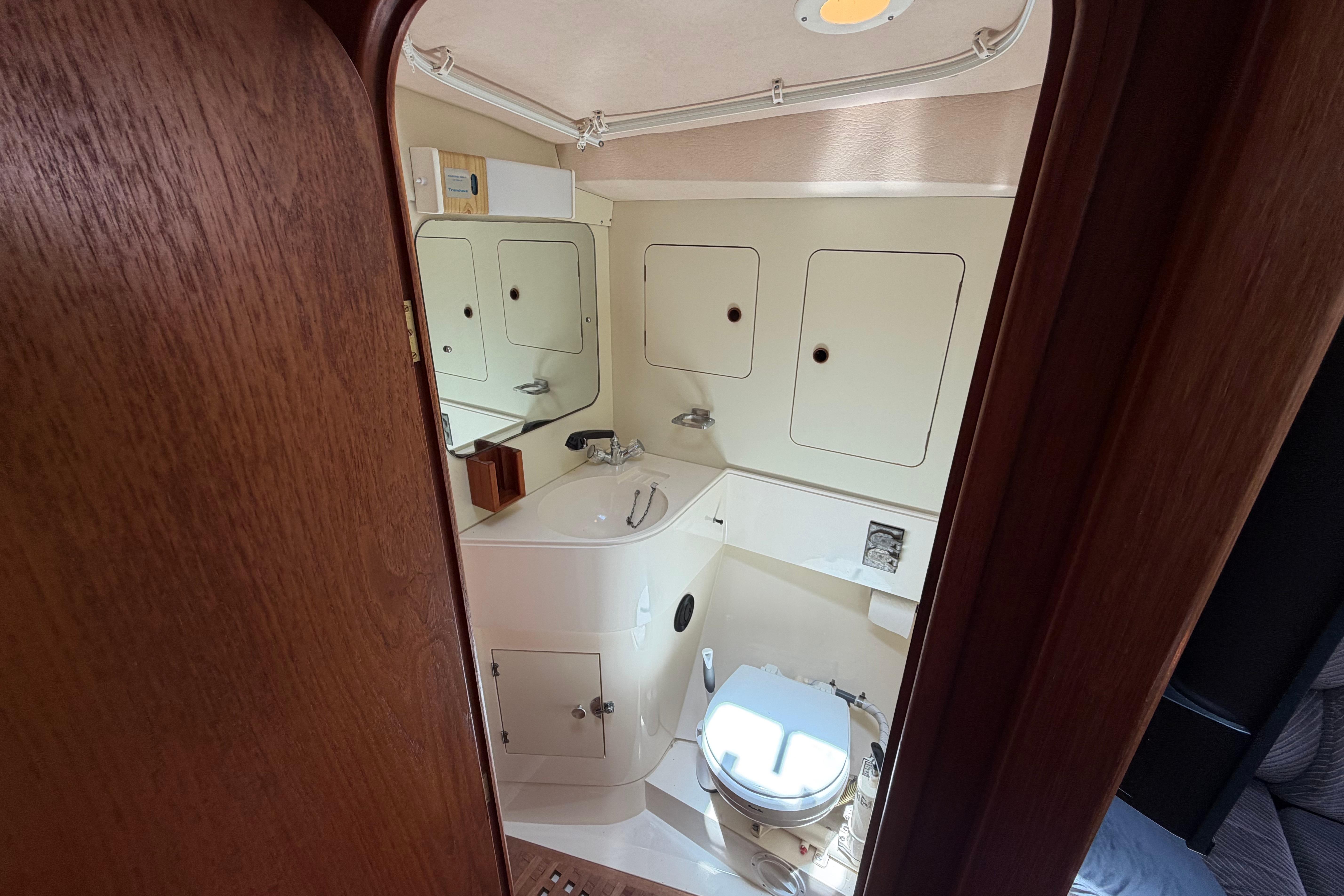 1987 Moody 376 yacht bathroom with sink, toilet, and storage cabinets.