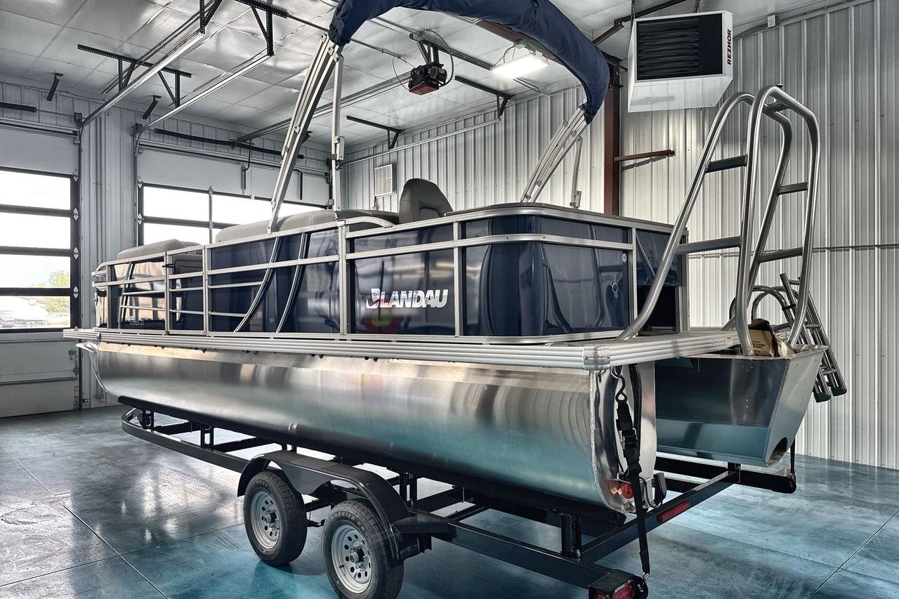 2026 Landau Island Breeze 23F pontoon boat in a garage setting.
