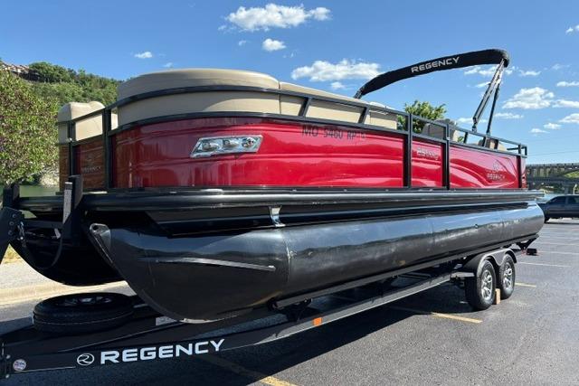 2025 Regency 250 DL3 pontoon boat on trailer, red and black design, sunny day.