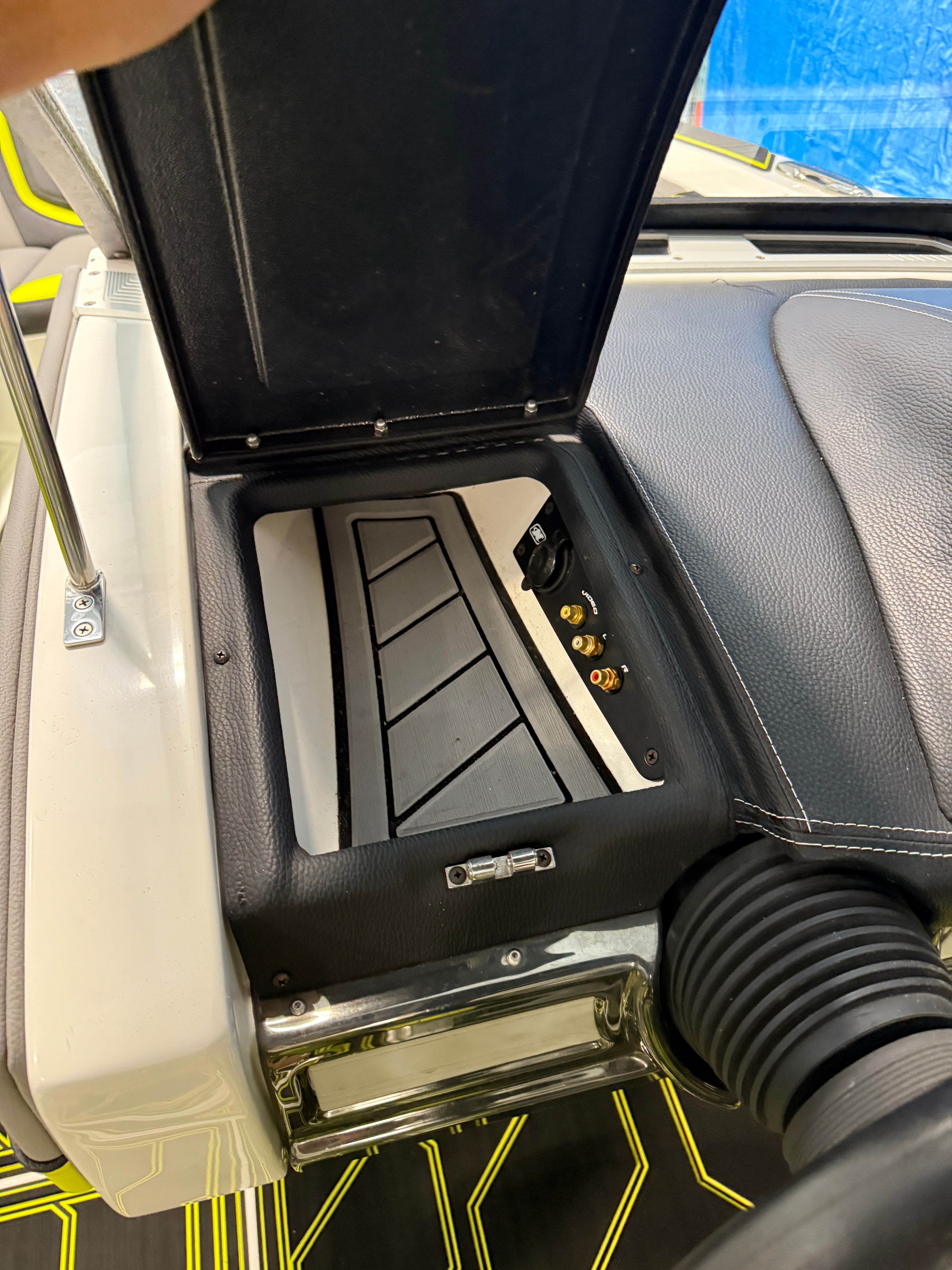 An open storage compartment on a boat with connectors and cables.