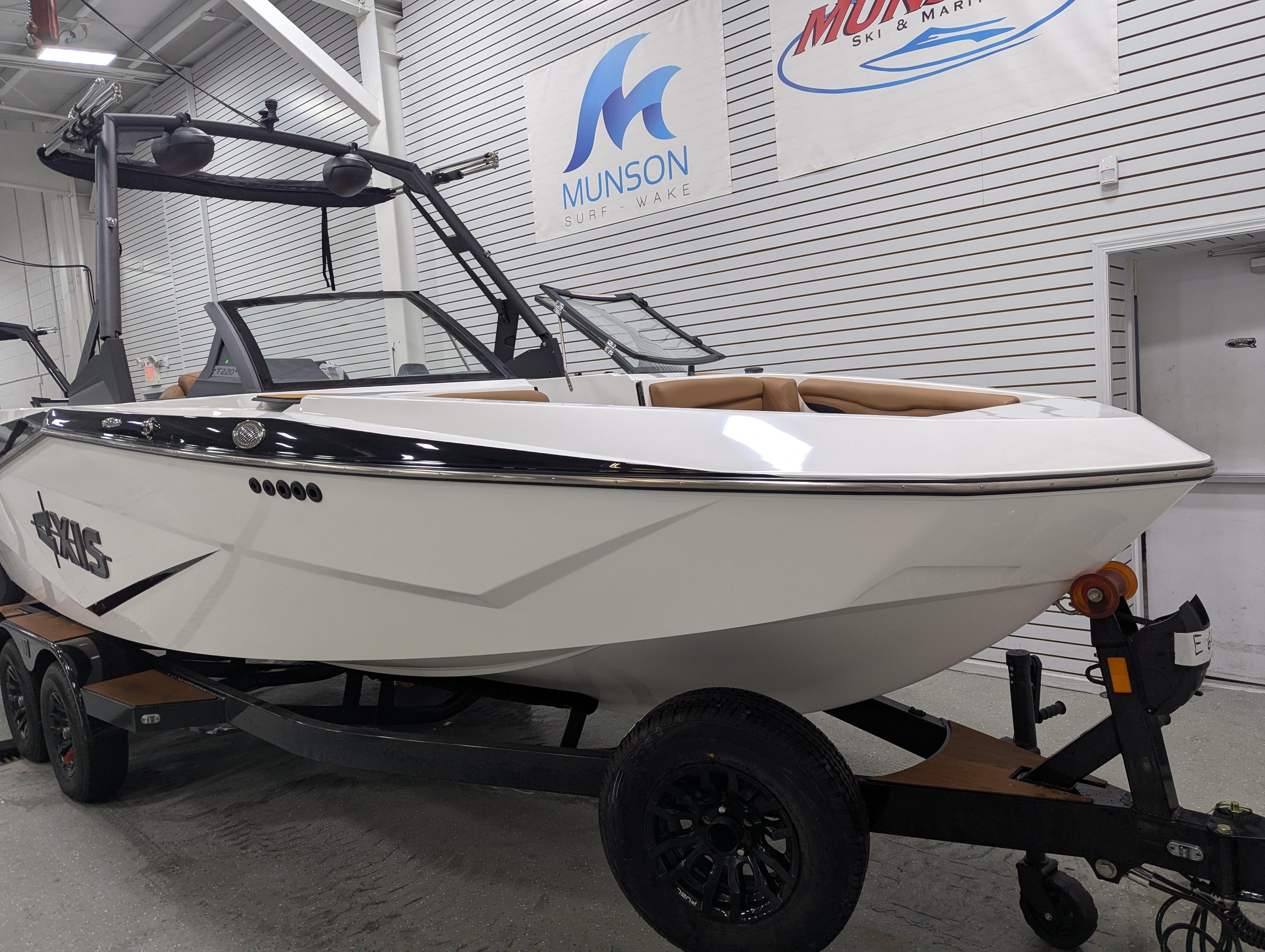 2025 Axis T220 boat on trailer in showroom, featuring sleek design and modern features.