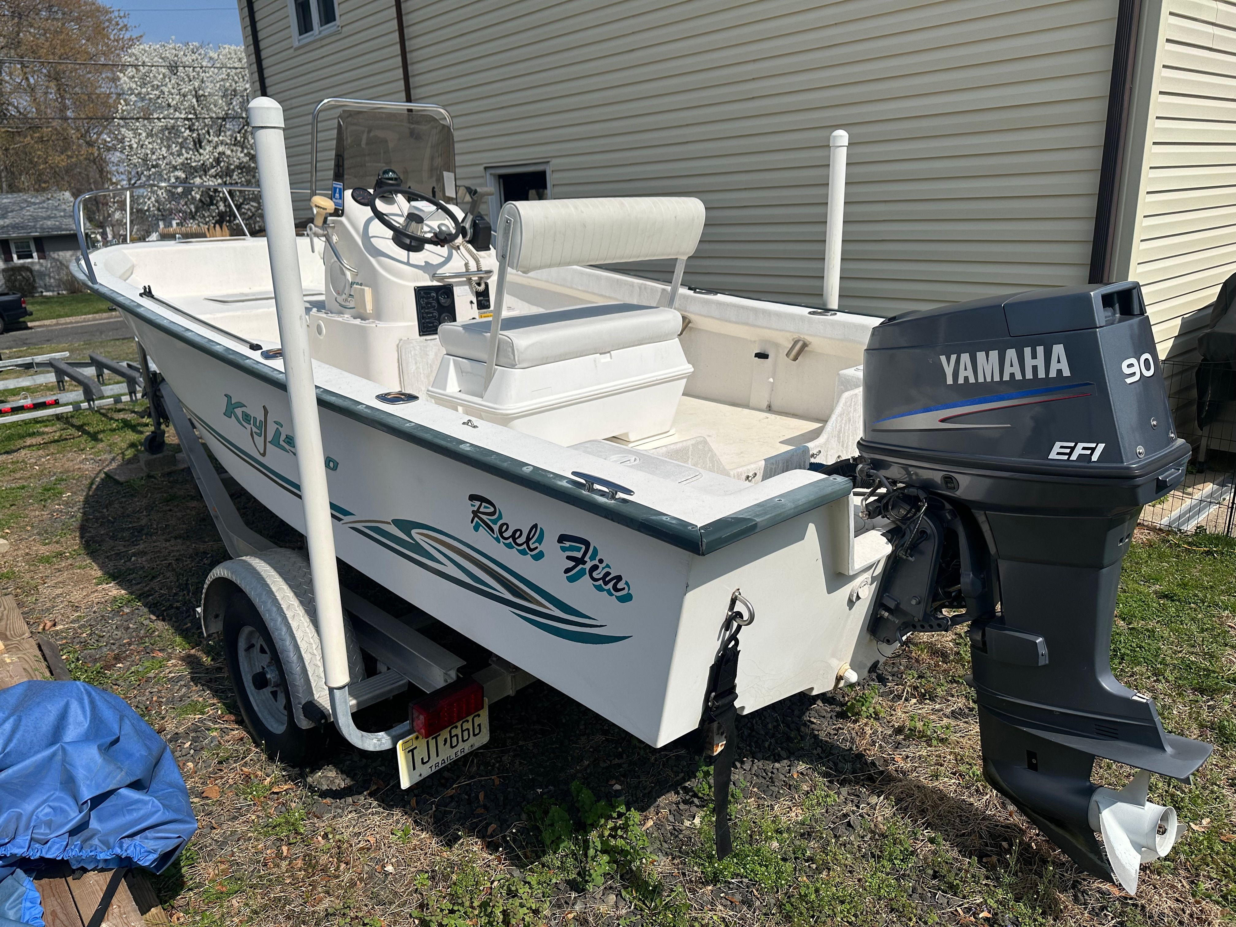 A 2003 Key Largo 180 Center Console boat on a trailer. It features a Yamaha 90 EFI outboard motor.
