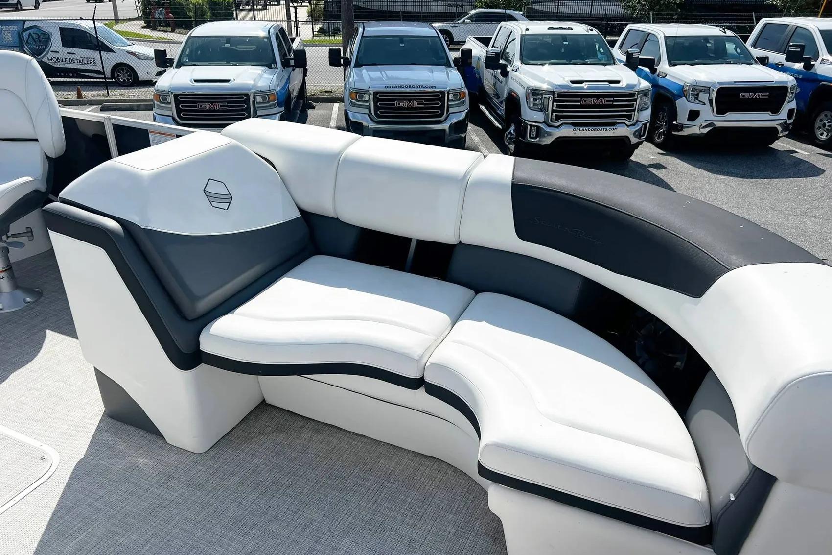 Luxury seating on 2023 South Bay 523 R boat, with parked GMC trucks in background.