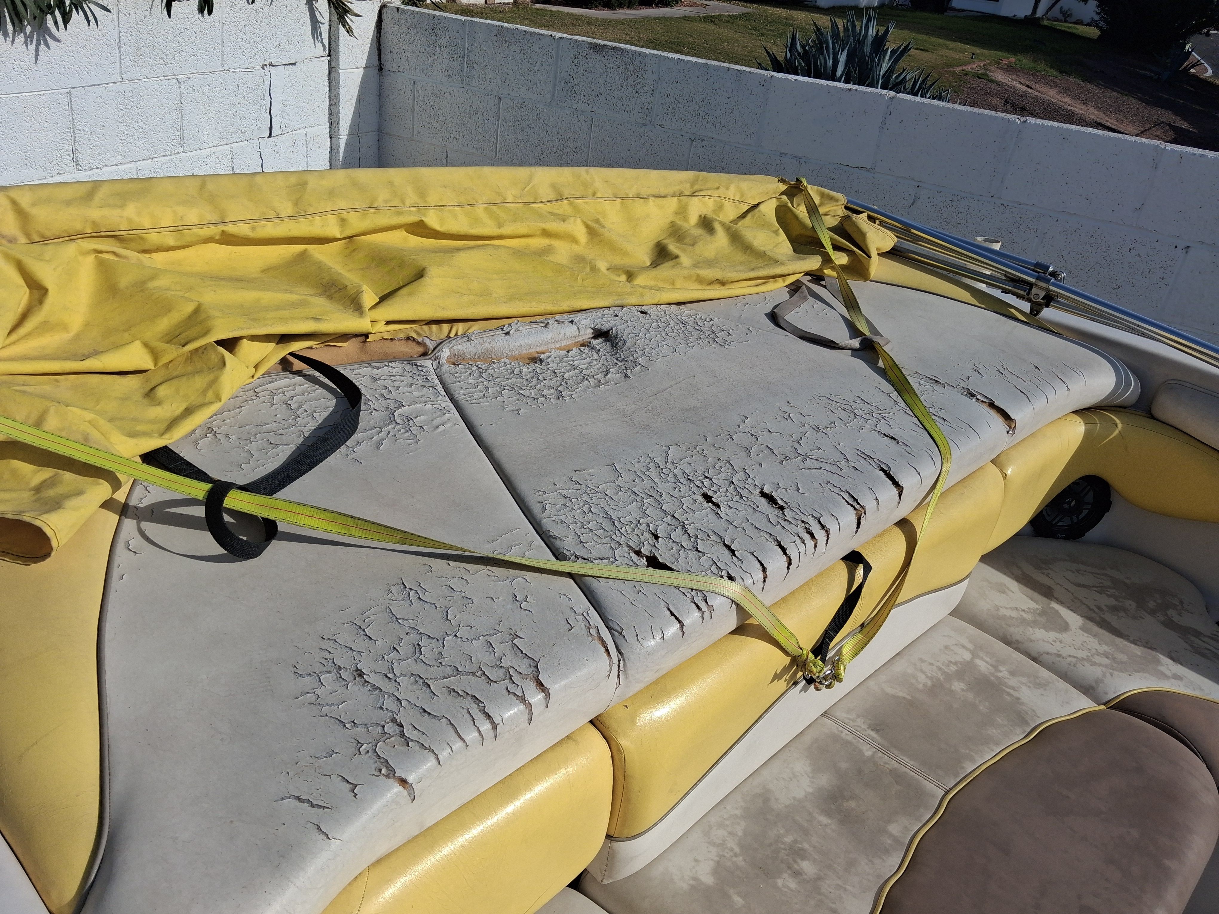 2004 Tracker Tahoe boat with worn seat upholstery and yellow cover.