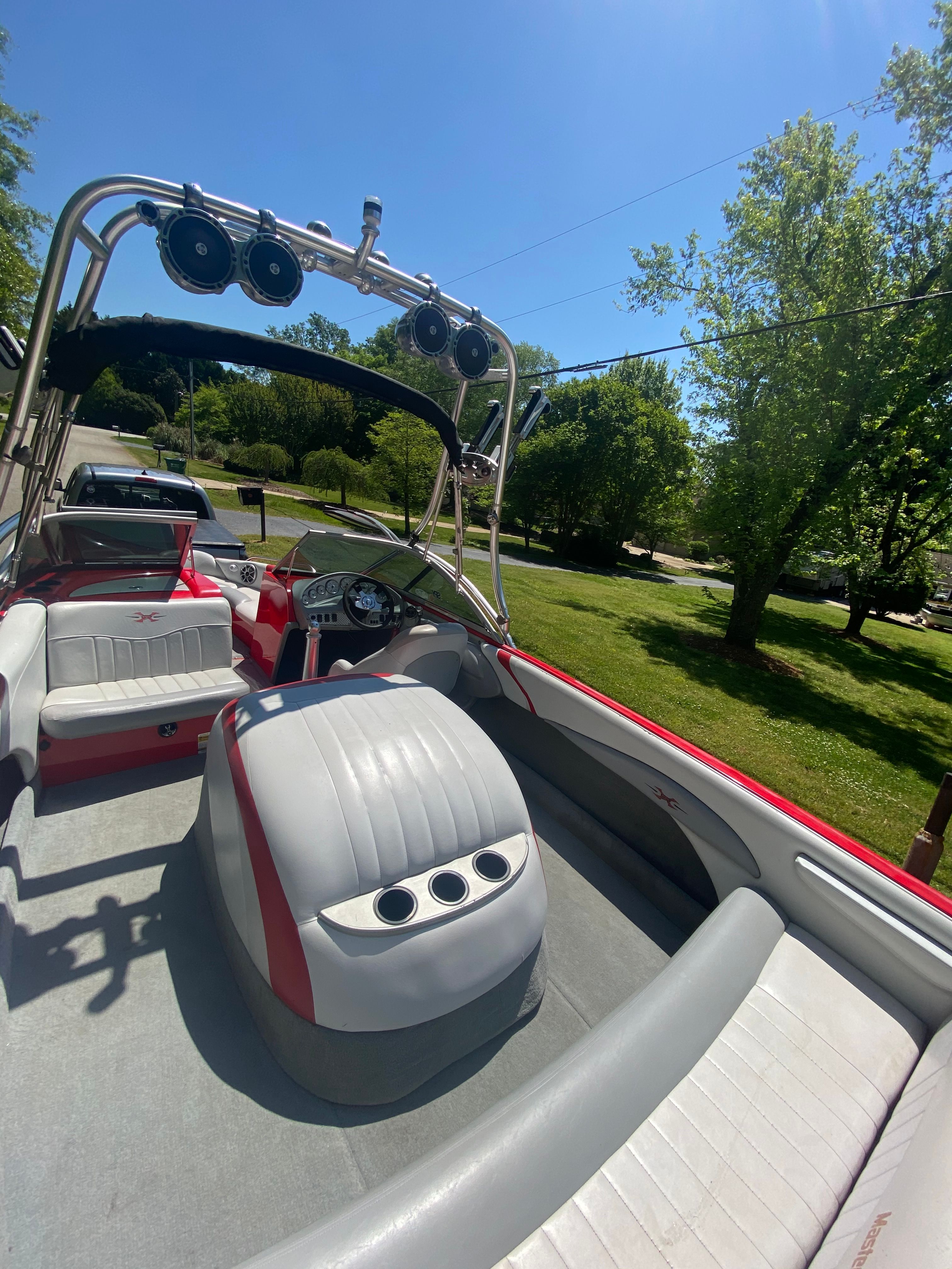 A 2004 MasterCraft X-9 boat with red and white seating, a tower, and speakers.