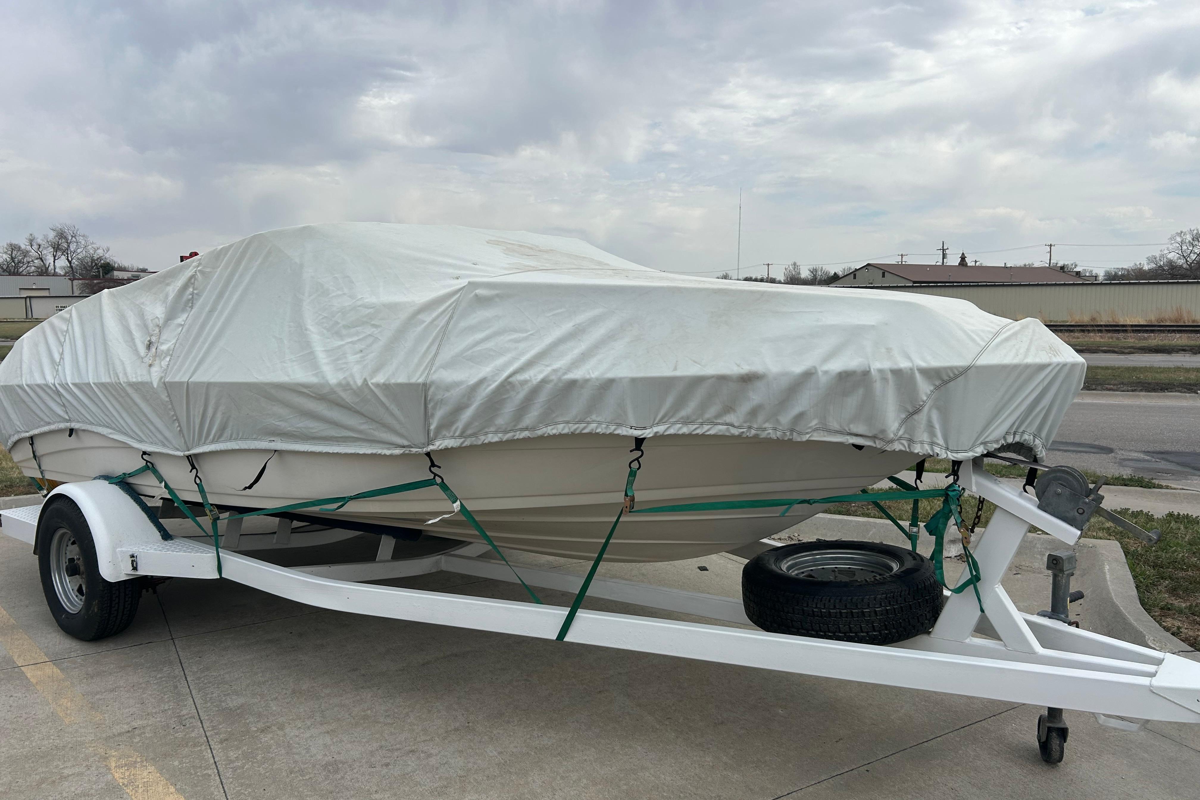 Covered 1996 Mariah 180 Shabah boat on trailer, parked outdoors.