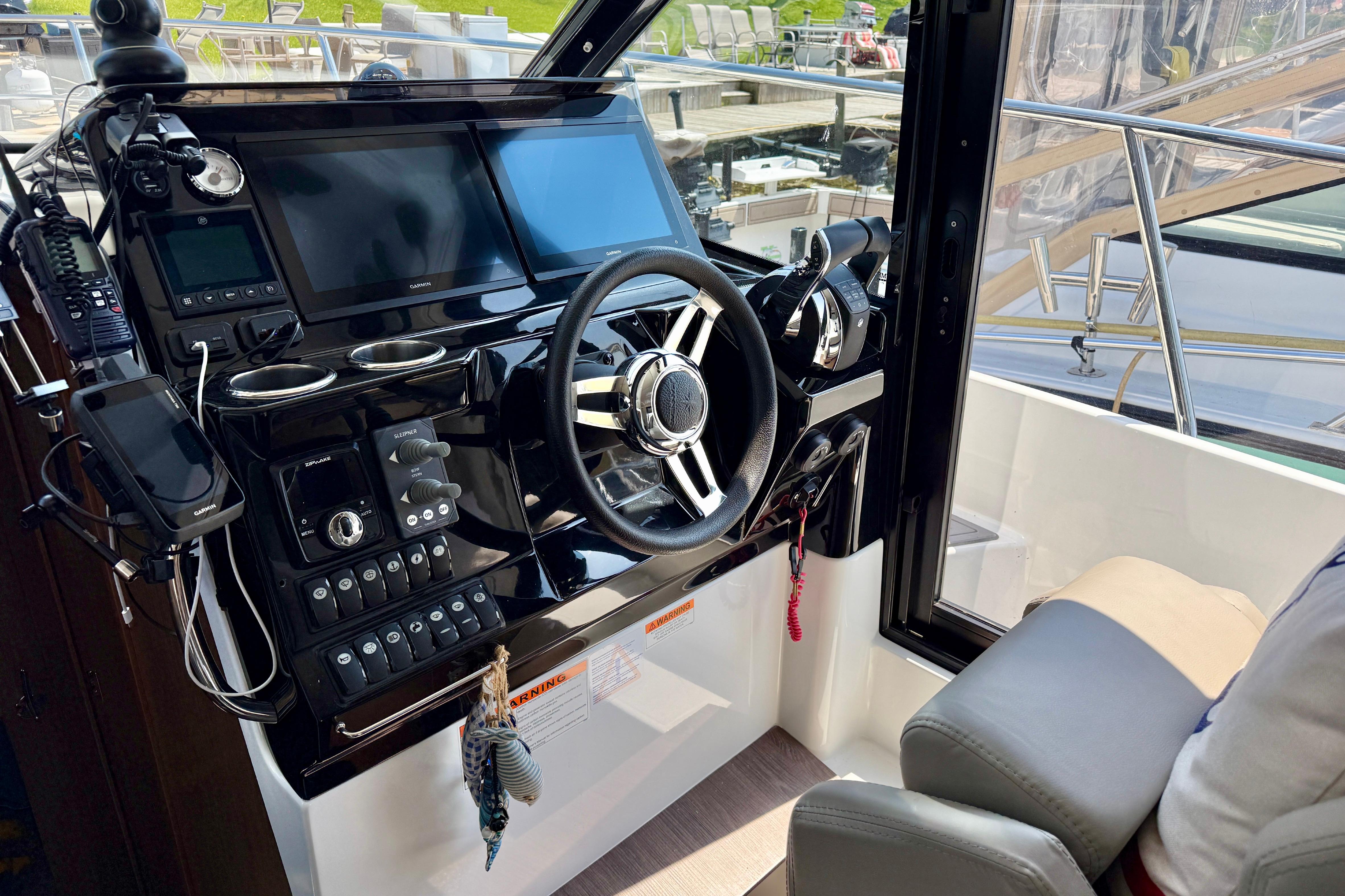Helm of 2022 Jeanneau NC 1095 Fly with modern navigation equipment and controls.