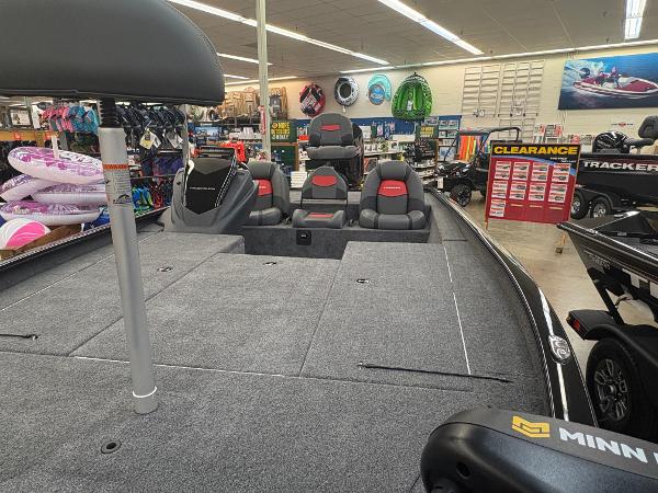 2025 Tracker Savage 215 boat interior in showroom with seating and accessories.