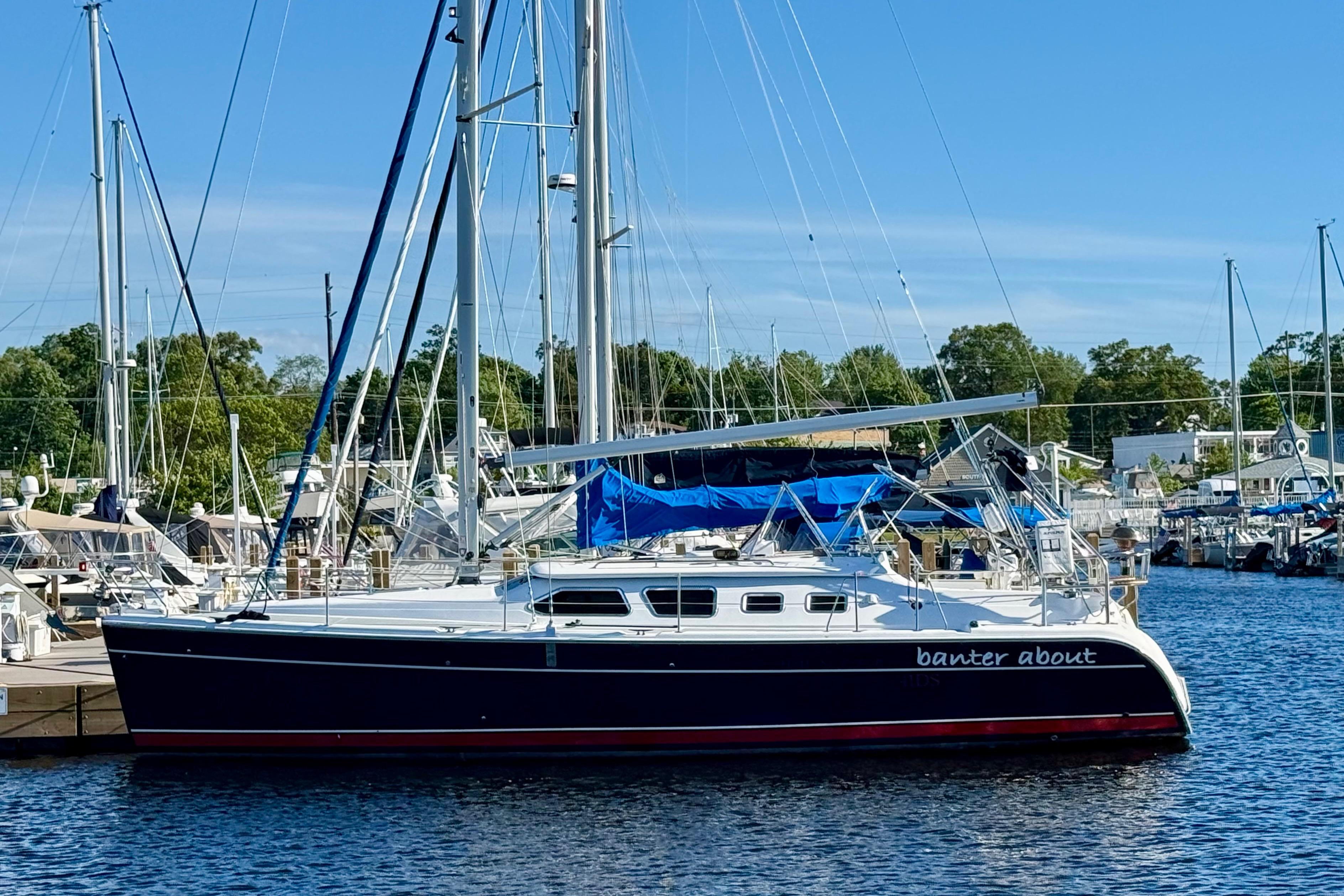2007 Hunter 41 Deck Salon sailboat docked at a marina under clear blue skies.