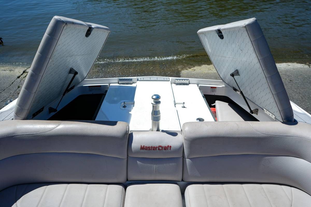 The image shows the stern of a MasterCraft X-45 boat with open storage compartments.