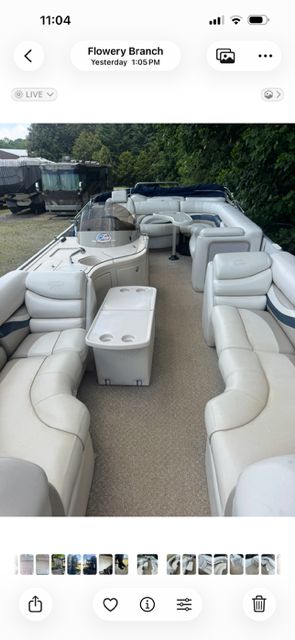 Interior view of a pontoon boat with white seating and a table.