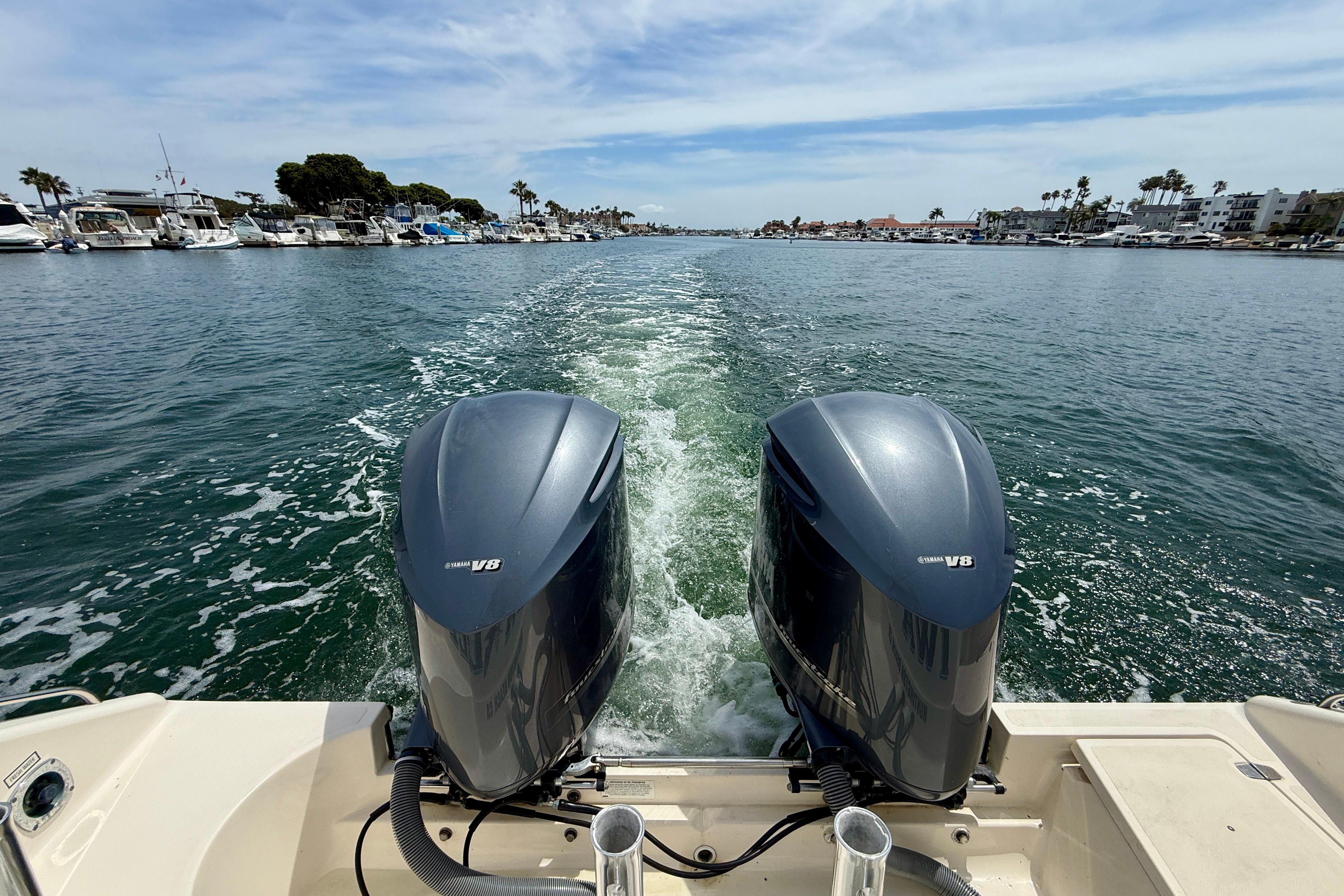 2012 Pursuit OS 345 Offshore boat with twin Yamaha V8 engines cruising in a marina.