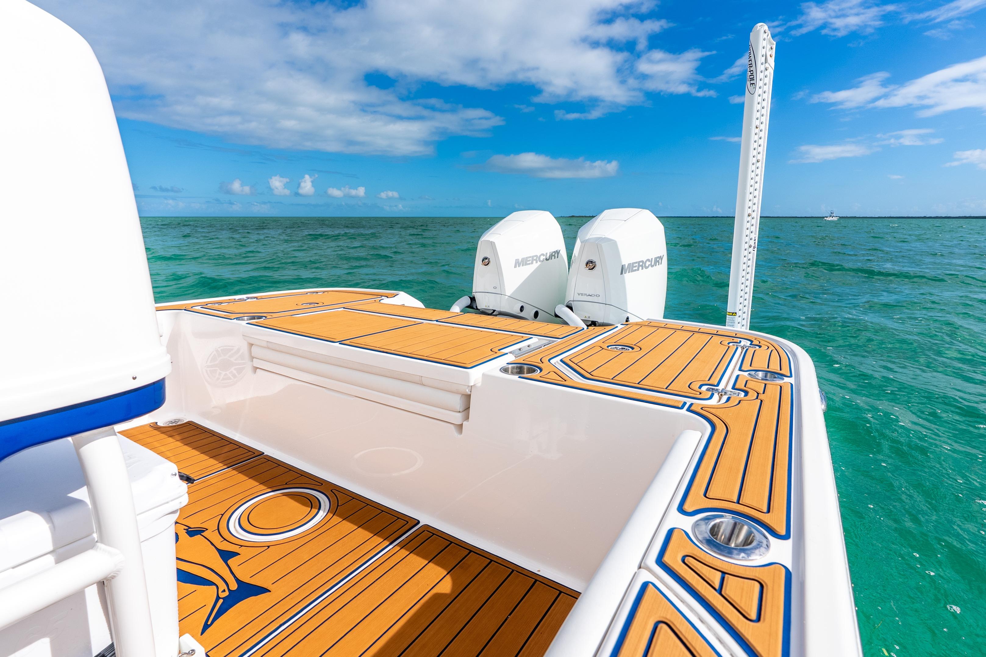 2024 Caymas 281 HB boat with dual Mercury engines on turquoise water.