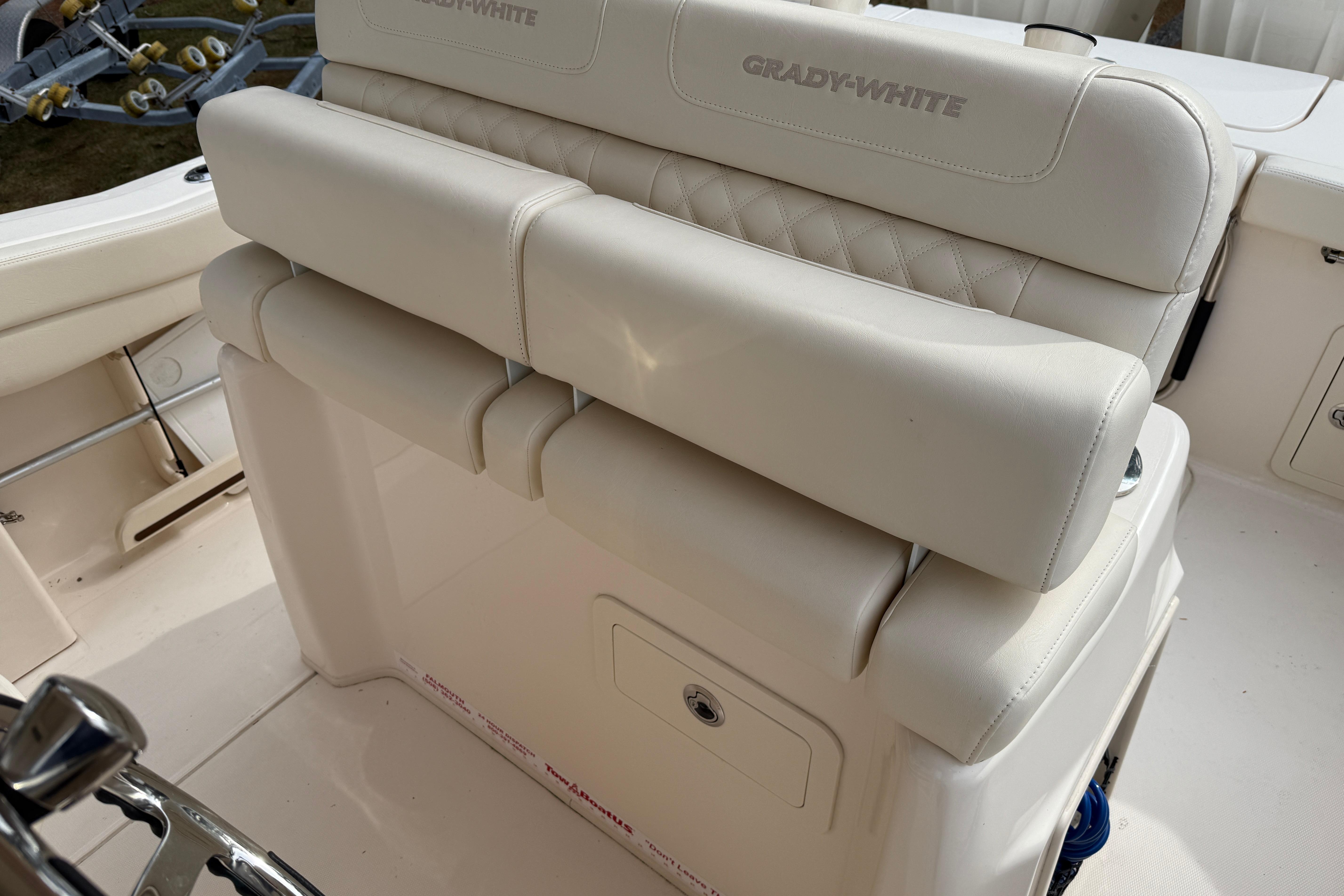 2024 Grady-White Canyon 271 boat seating with white upholstery and storage compartment.