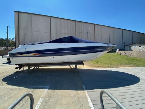 2005 Bayliner 249 SD boat on trailer, parked outdoors near a large building.