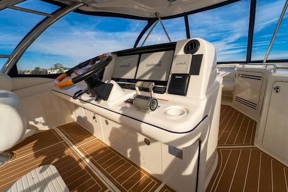 2006 Sea Ray 580 Sedan Bridge helm with modern navigation equipment and wooden flooring.