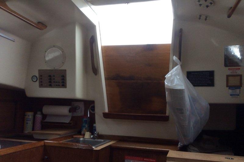 Interior of a 1980 Sloop 27.7 Bristol sailboat, featuring a compact kitchen area.