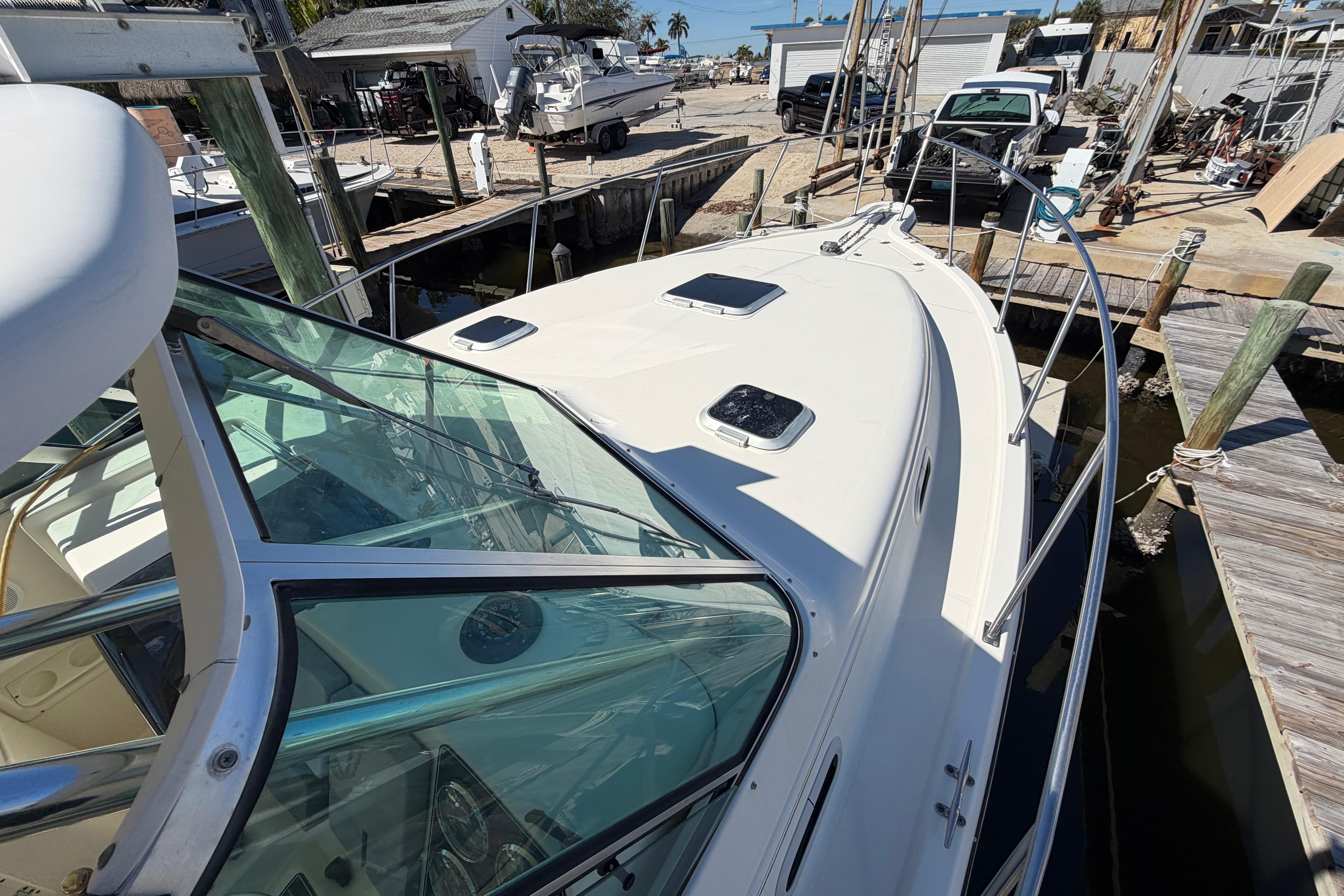 2001 Pursuit 3000 Express boat docked at a marina, showcasing sleek design and glass windows.