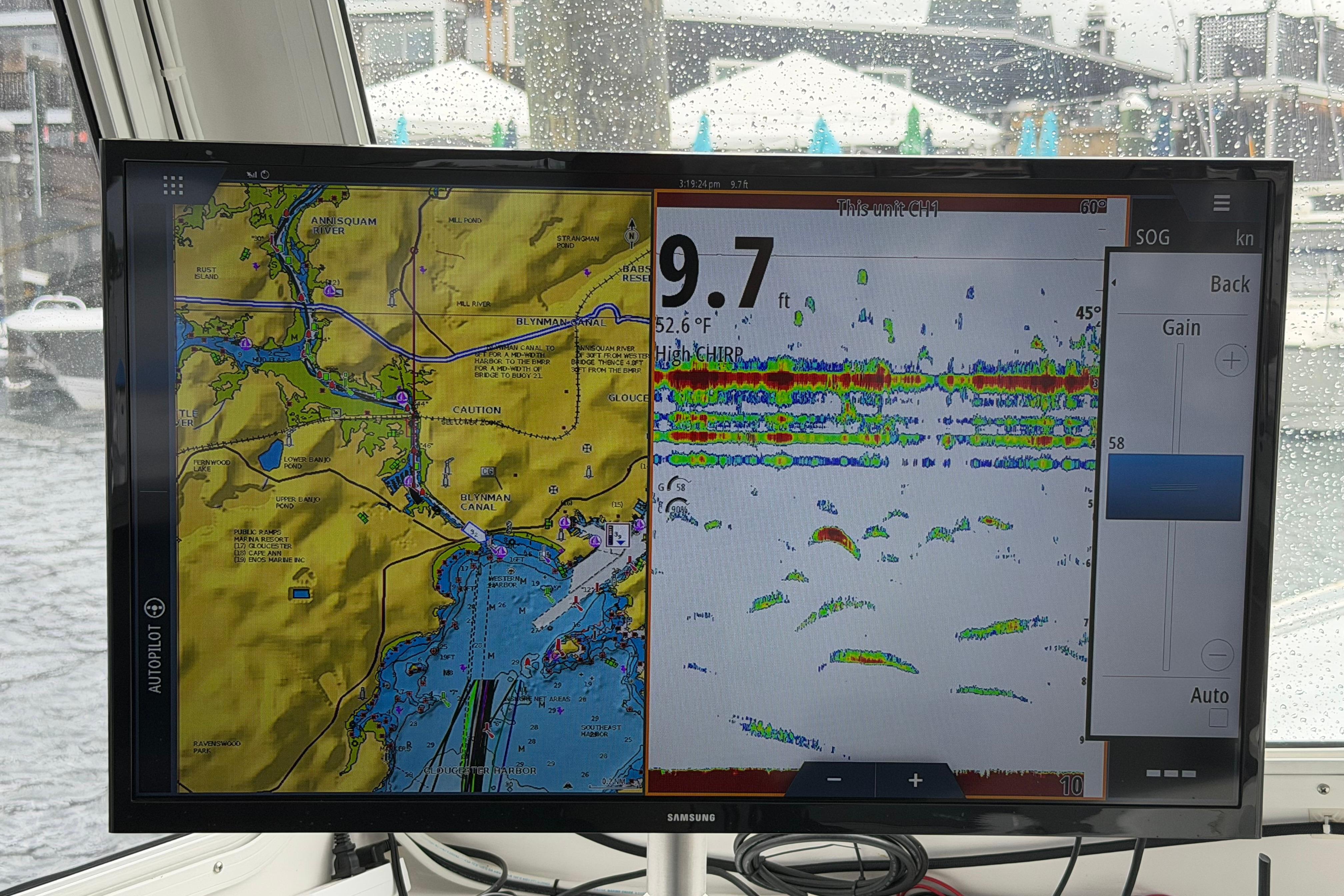 Boat navigation screen displaying map and sonar data on a rainy day.